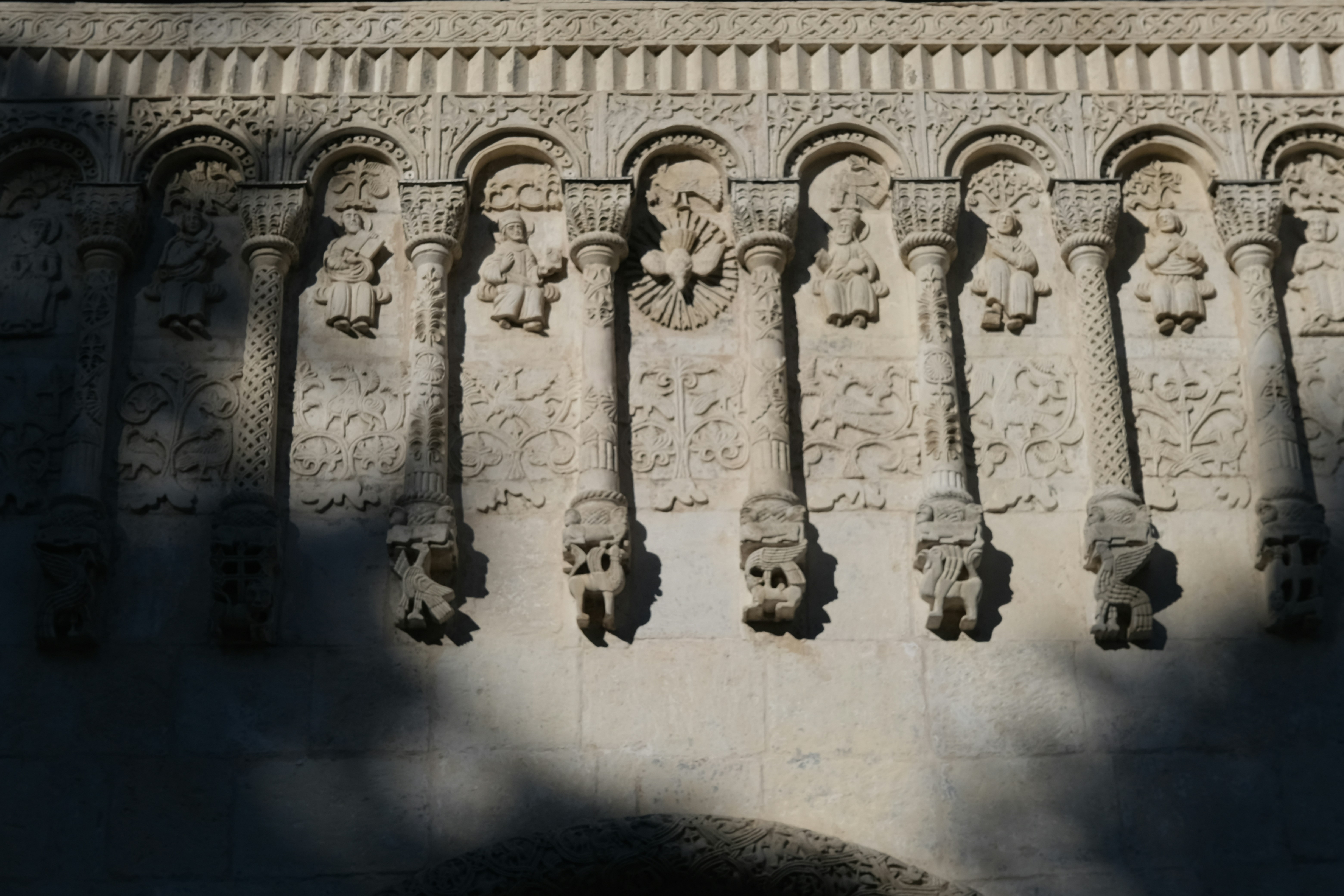 Ornate stone wall with carved pillars and figures