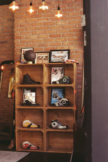 Wooden crate shelves displaying shoes against a brick wall