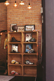 Wooden crate shelves displaying shoes against a brick wall