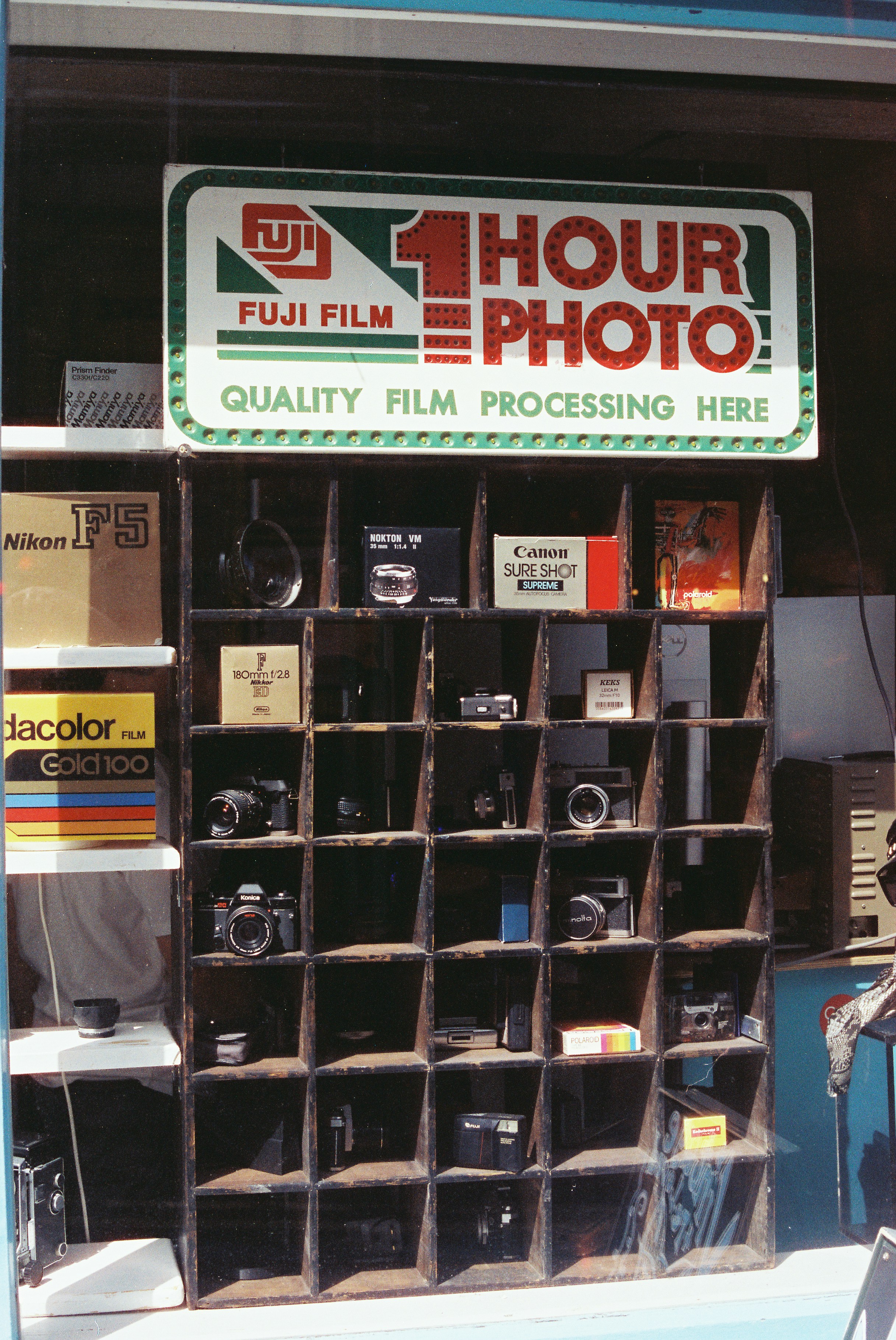 Fuji film 1 hour photo sign above cameras in window.