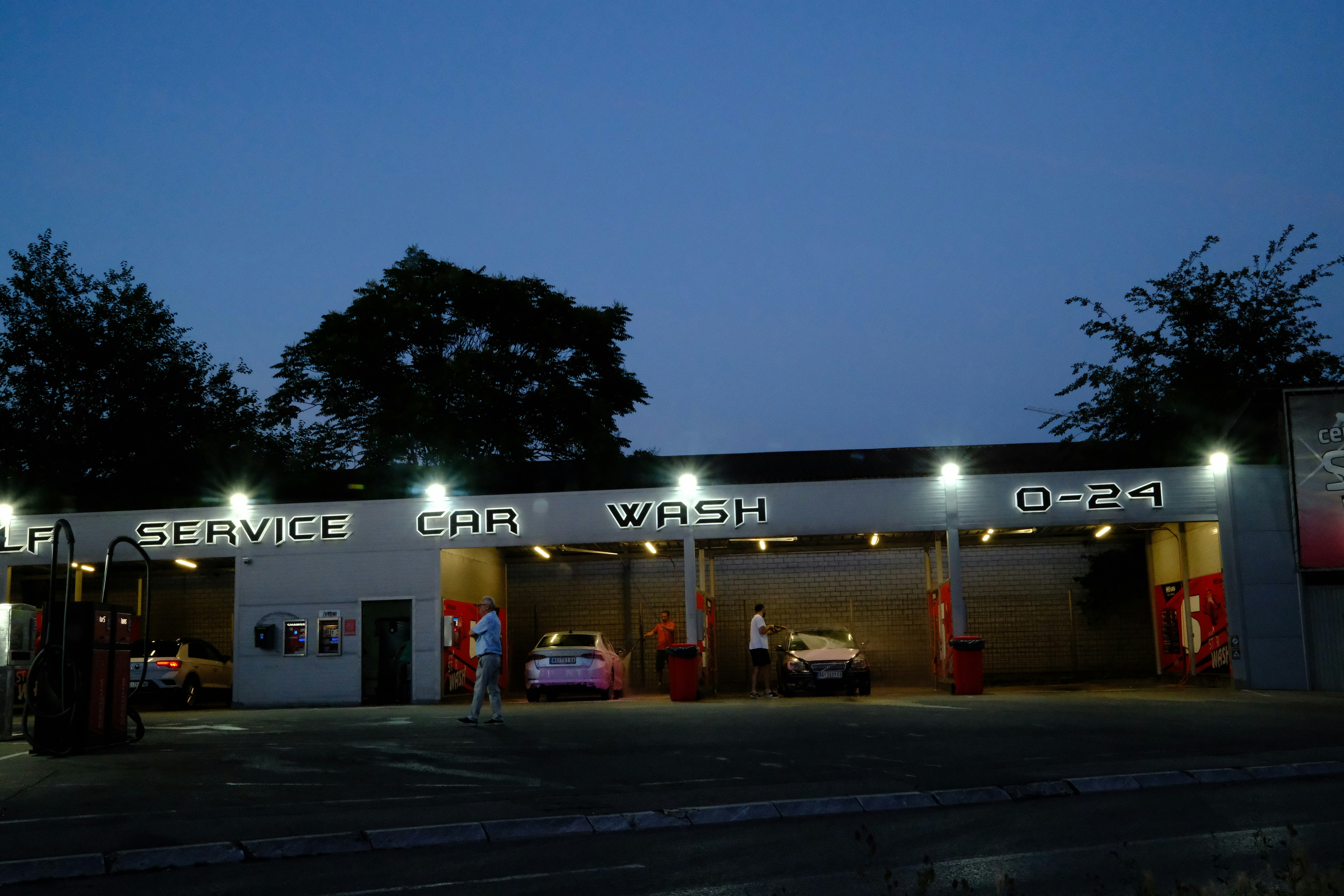 A car wash and service station lit up at night.