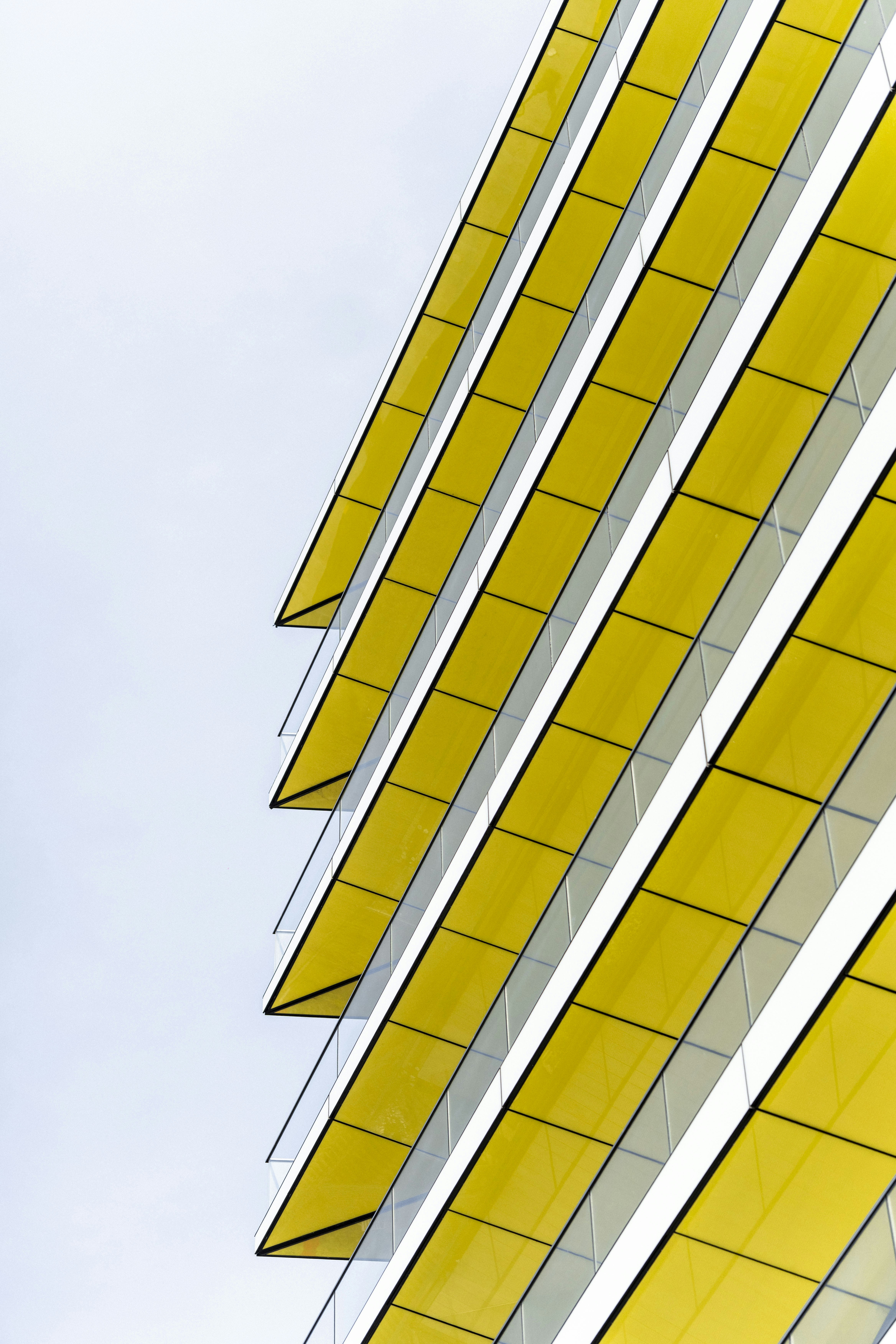 Modern building facade with vibrant yellow balconies.