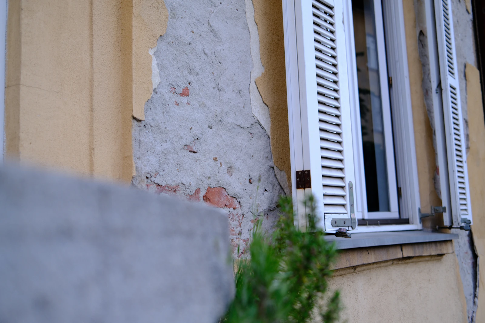 Mur à la peinture écaillée autour d'une fenêtre