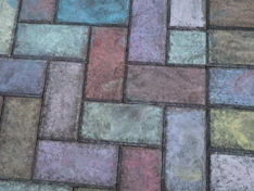 Paving stones covered in multicolored chalk drawings.