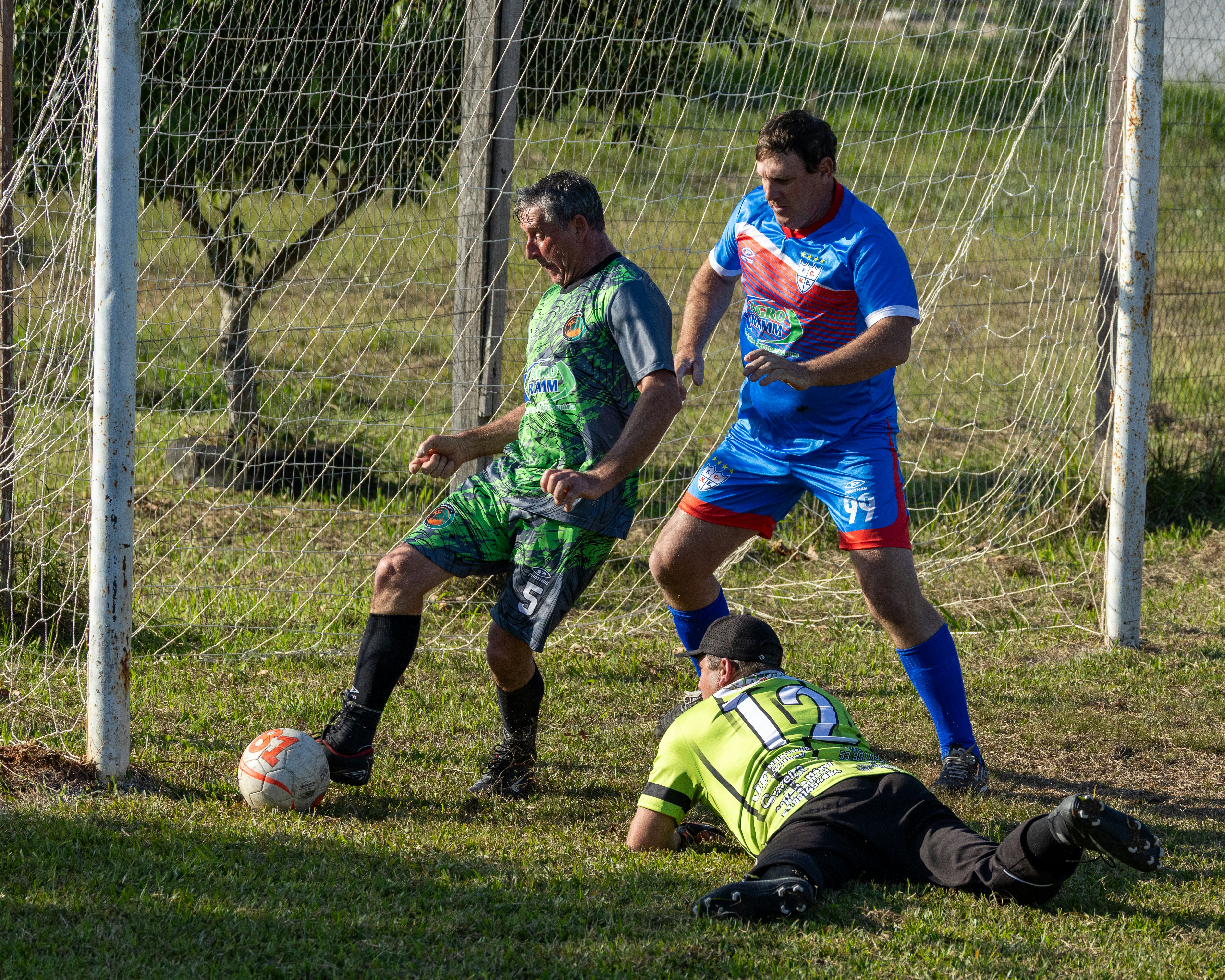 Pemain sepak bola bersaing memperebutkan bola di dekat gawang.