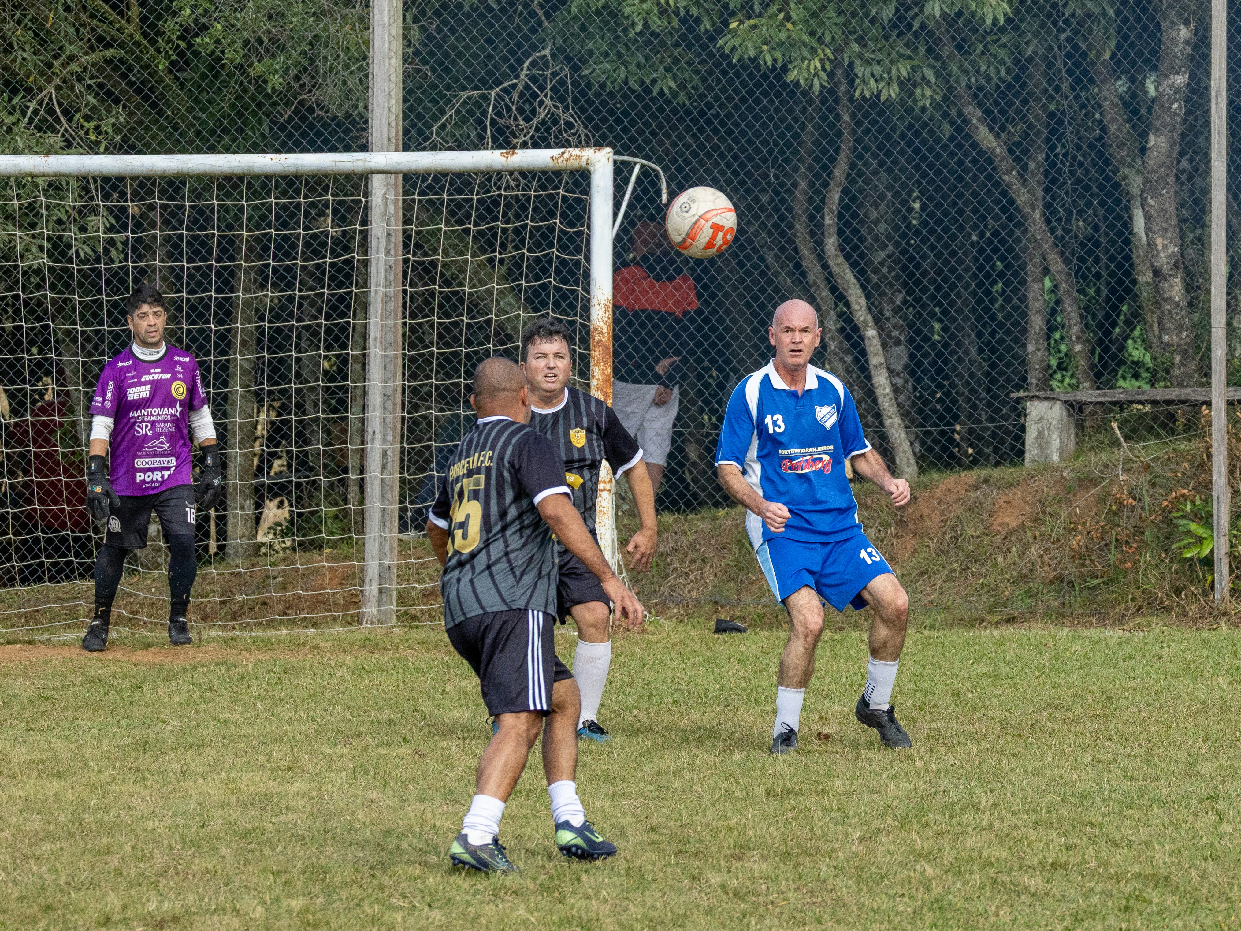 Pemain sepak bola menyundul bola selama pertandingan.