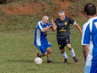 Two men playing soccer on a grassy field.