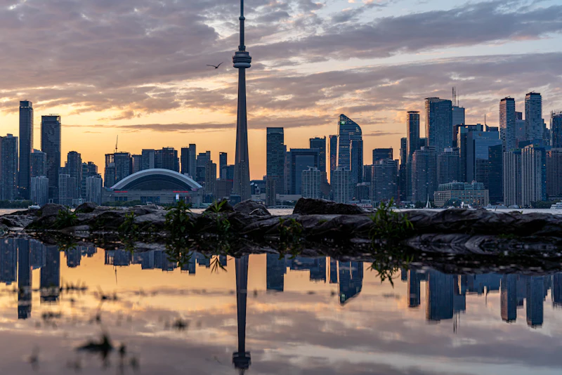 The Toronto skyline and CN Tower reflected at sunset