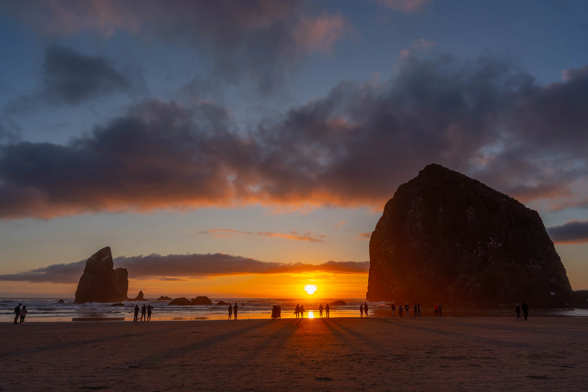 Vibrant sunset over a beach with large sea stacks.