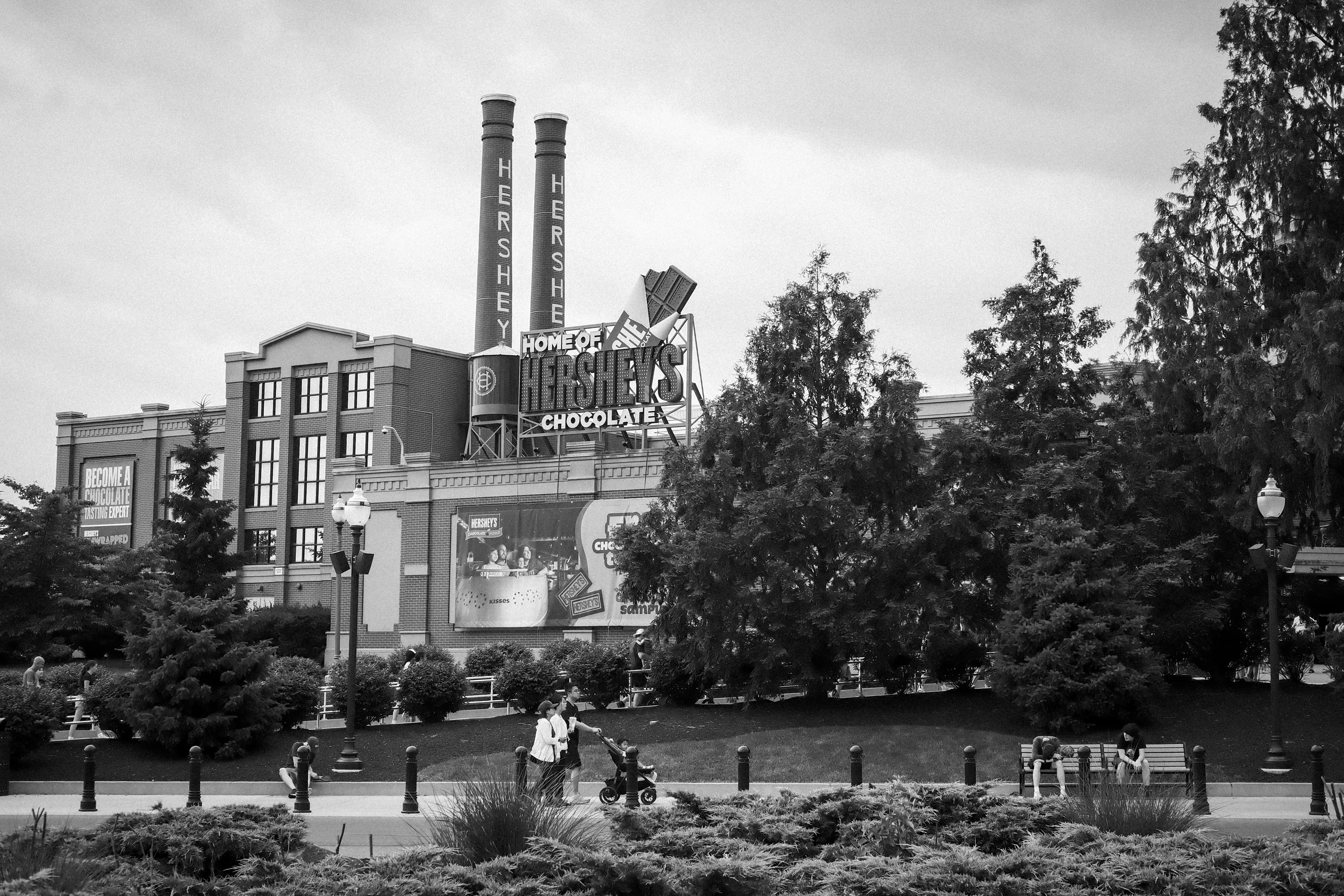 Black and white hershey's factory building with smokestacks and trees.