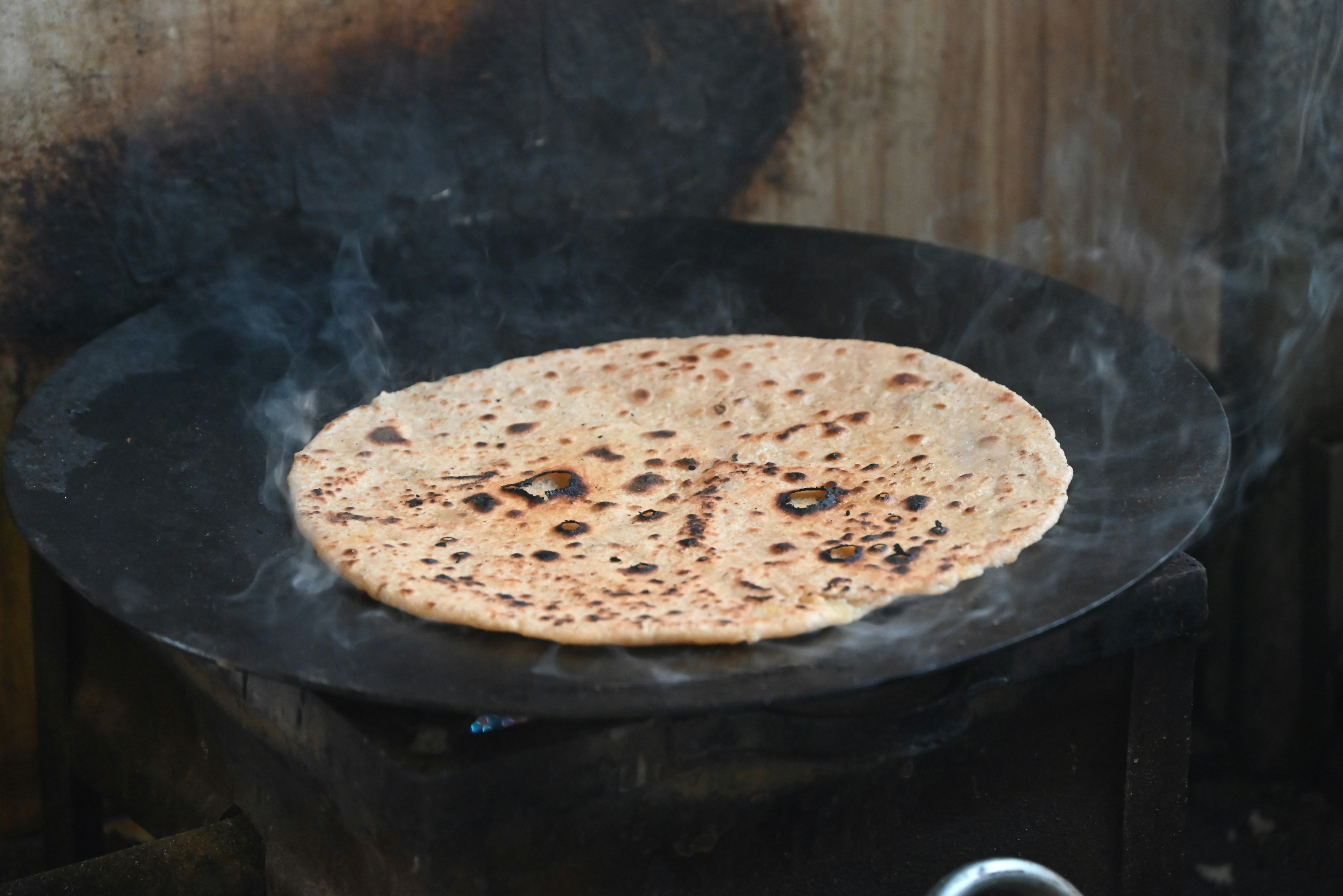 Una pane piatto cotta su una piastra calda con il fumo.