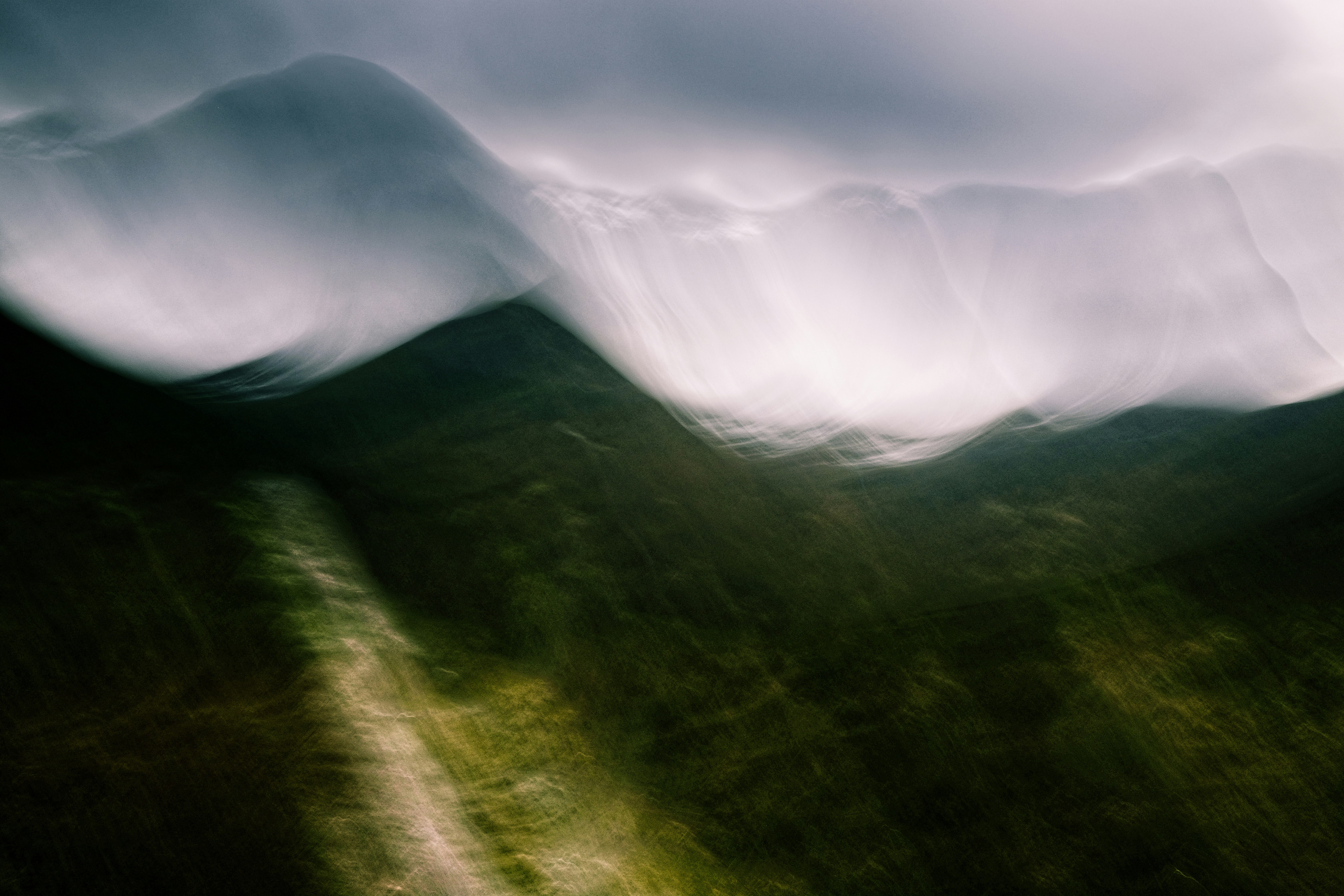 Abstract blurred mountain landscape with a winding path.