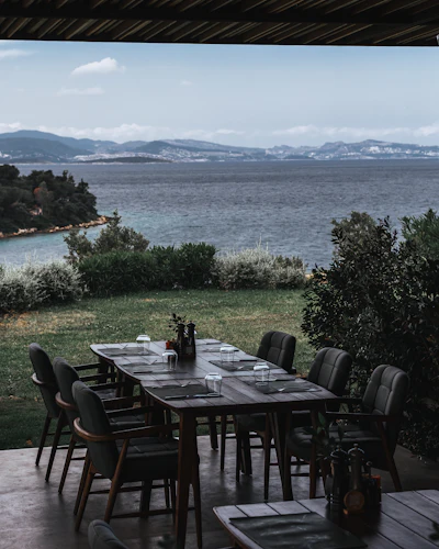 An outdoor dining table overlooking a serene lake and distant mountains