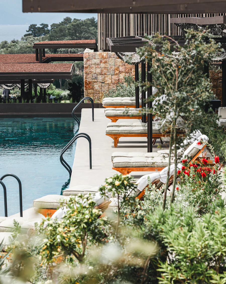 Pool and sun loungers surrounded by a garden
