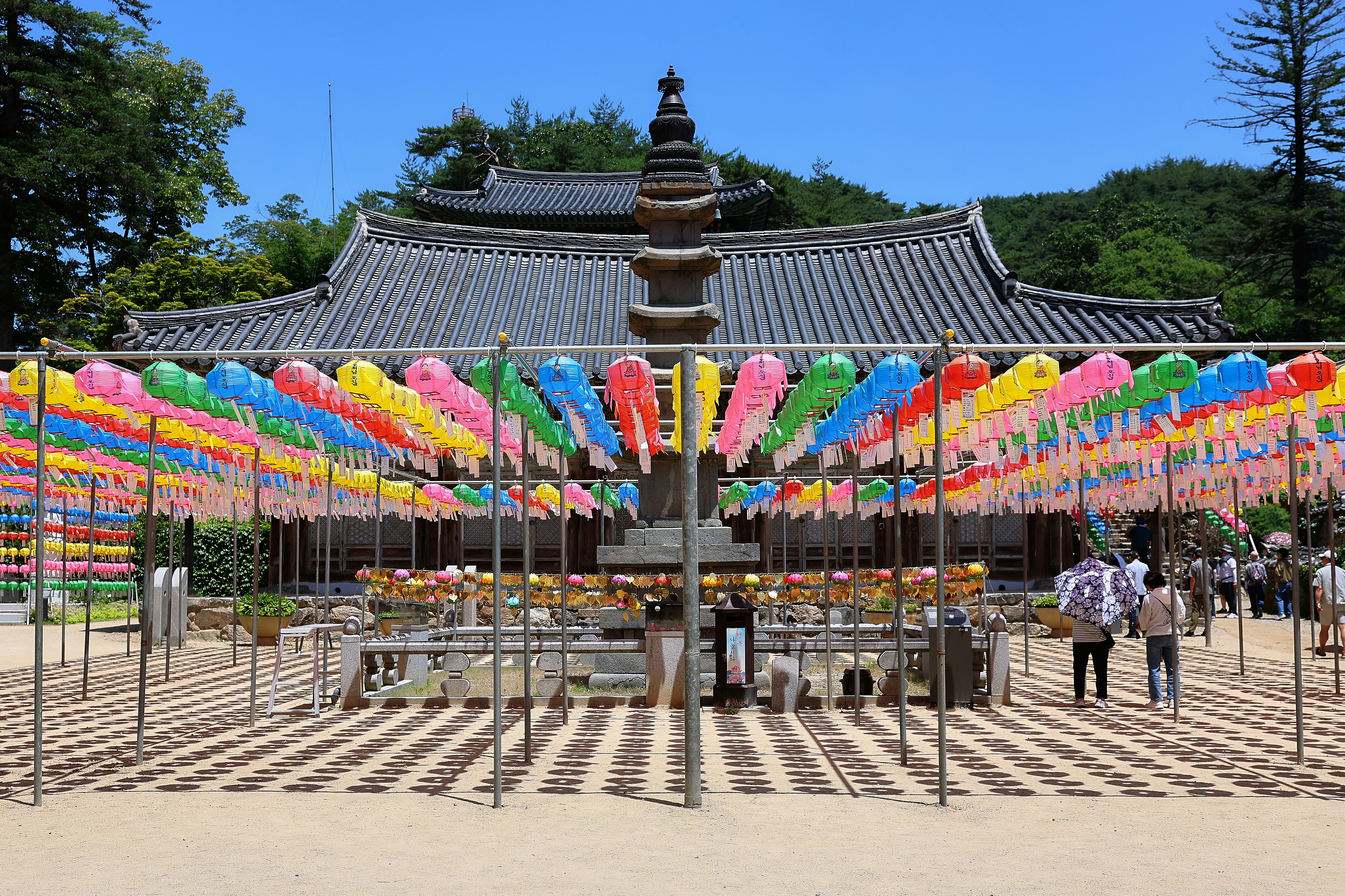 A traditional korean temple with a pagoda and colorful lanterns.