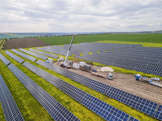 Aerial view of a solar panel field with a crane.