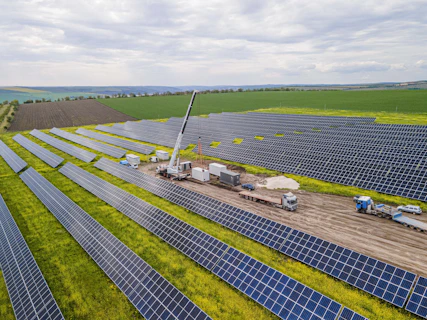 Aerial view of a solar panel field with a crane.