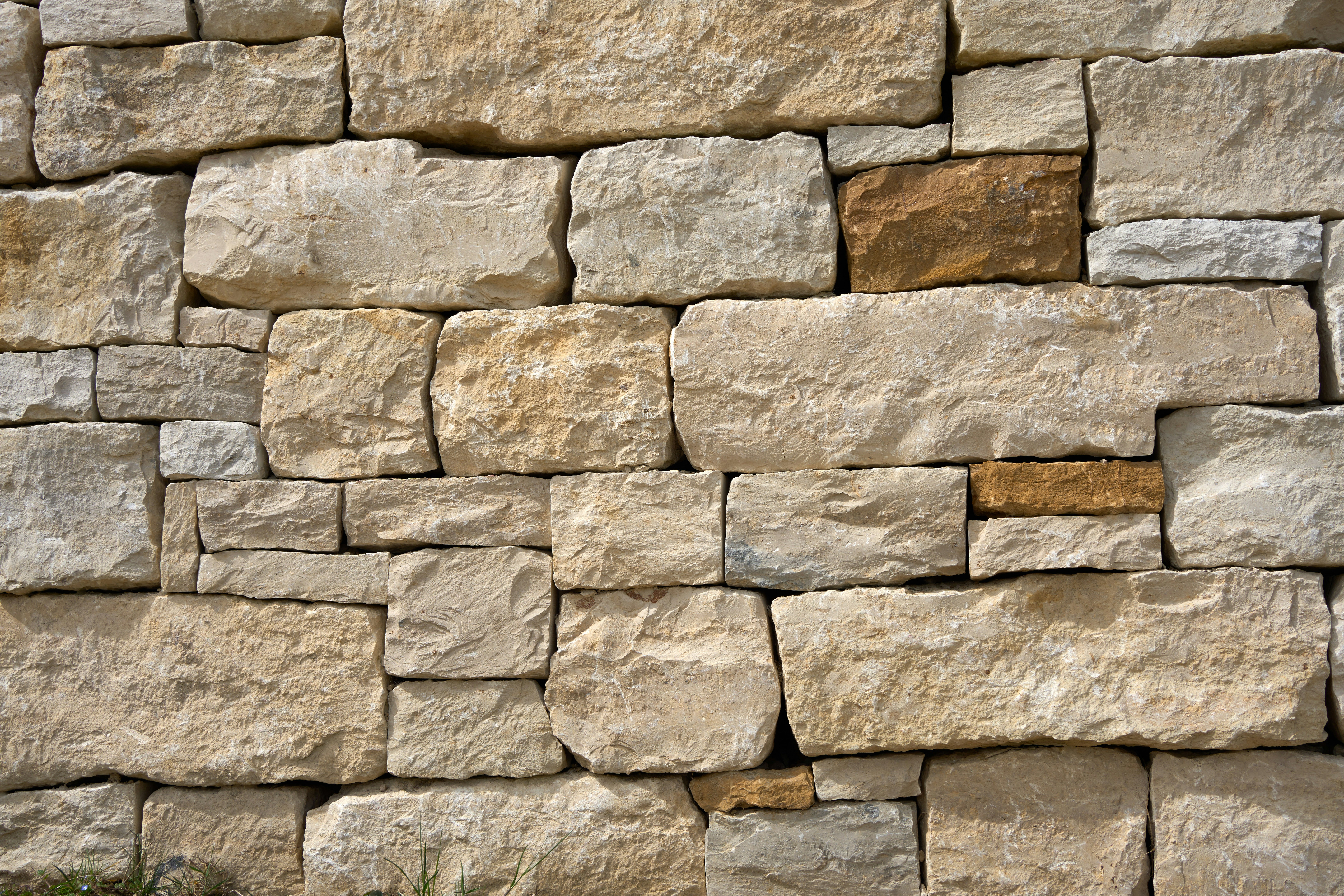 A rustic wall made of natural, uneven stone blocks.