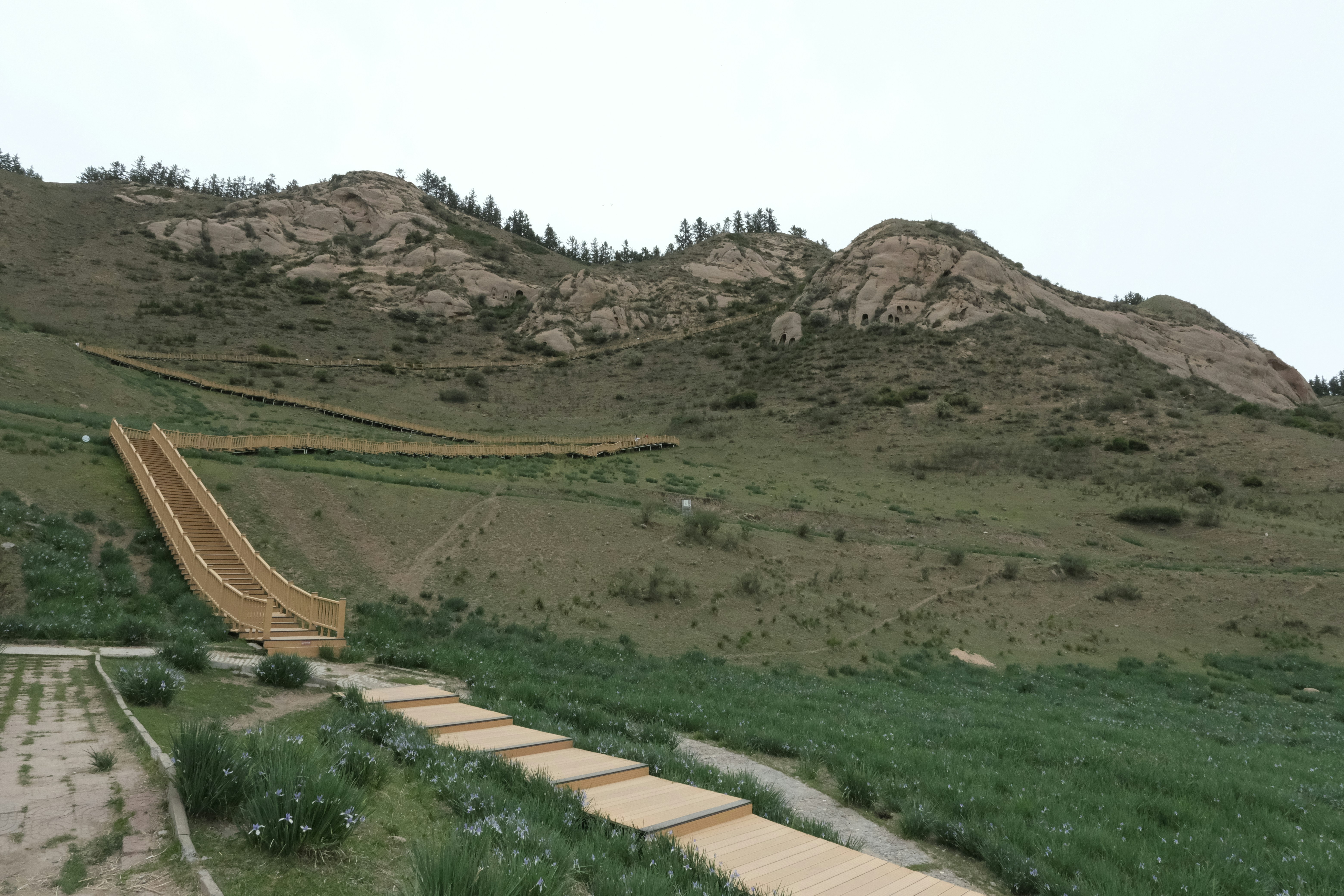Mountain landscape with rocky peaks, wooden stairs, and a slide.