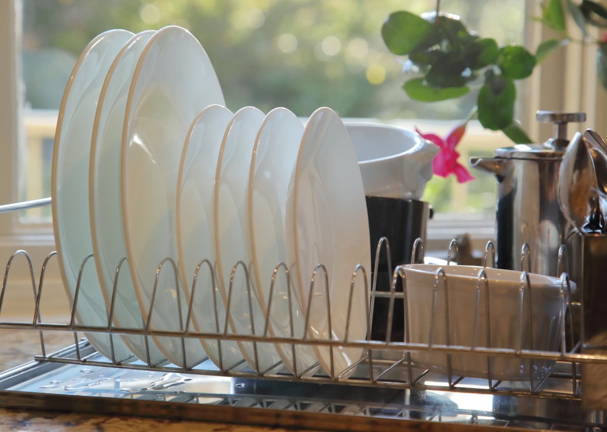 clean-white-plates-drying-in-a-metal-dish-rack-tfIxn4GW6yU collection background image