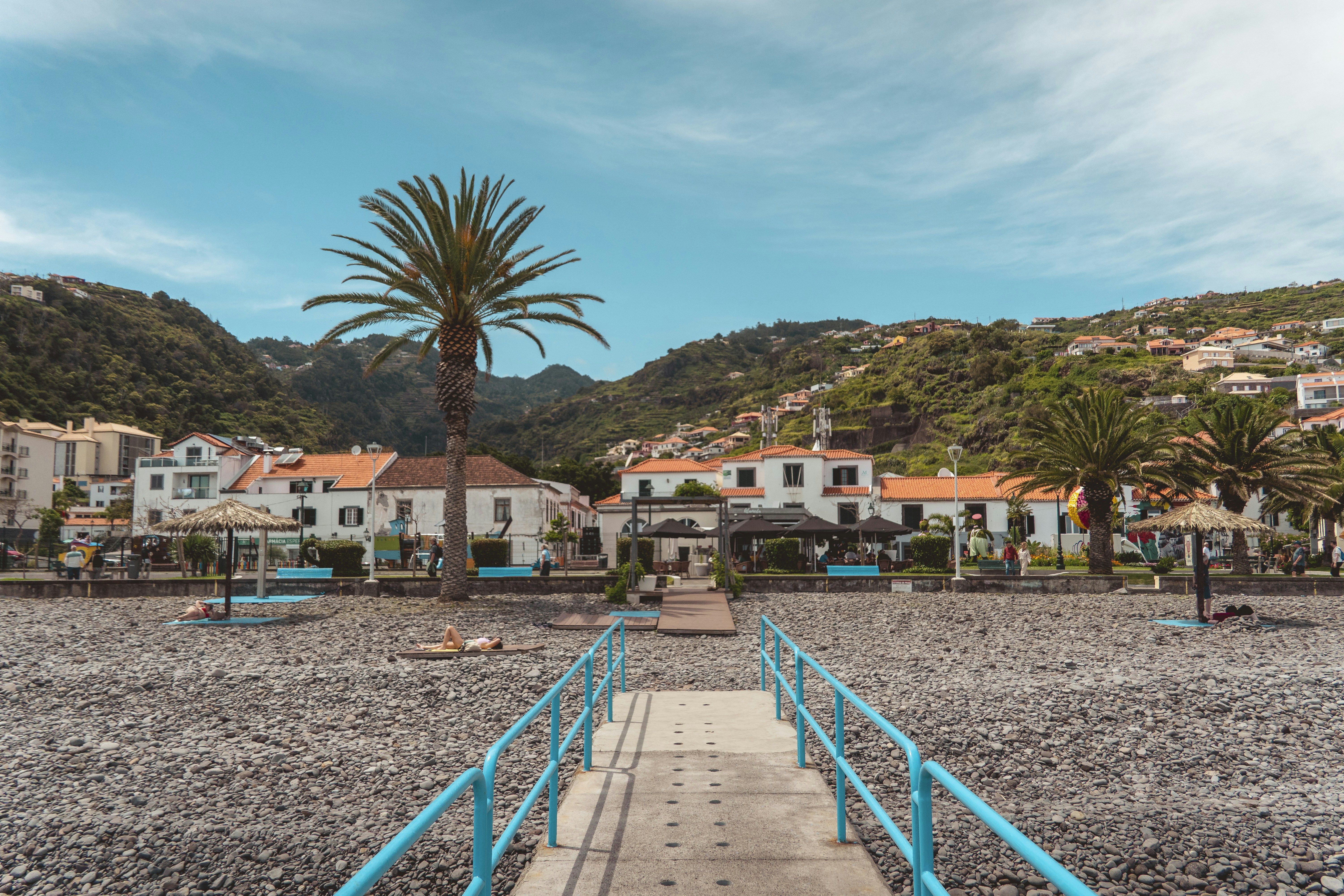 Pebble beach path leads to a charming coastal village.
