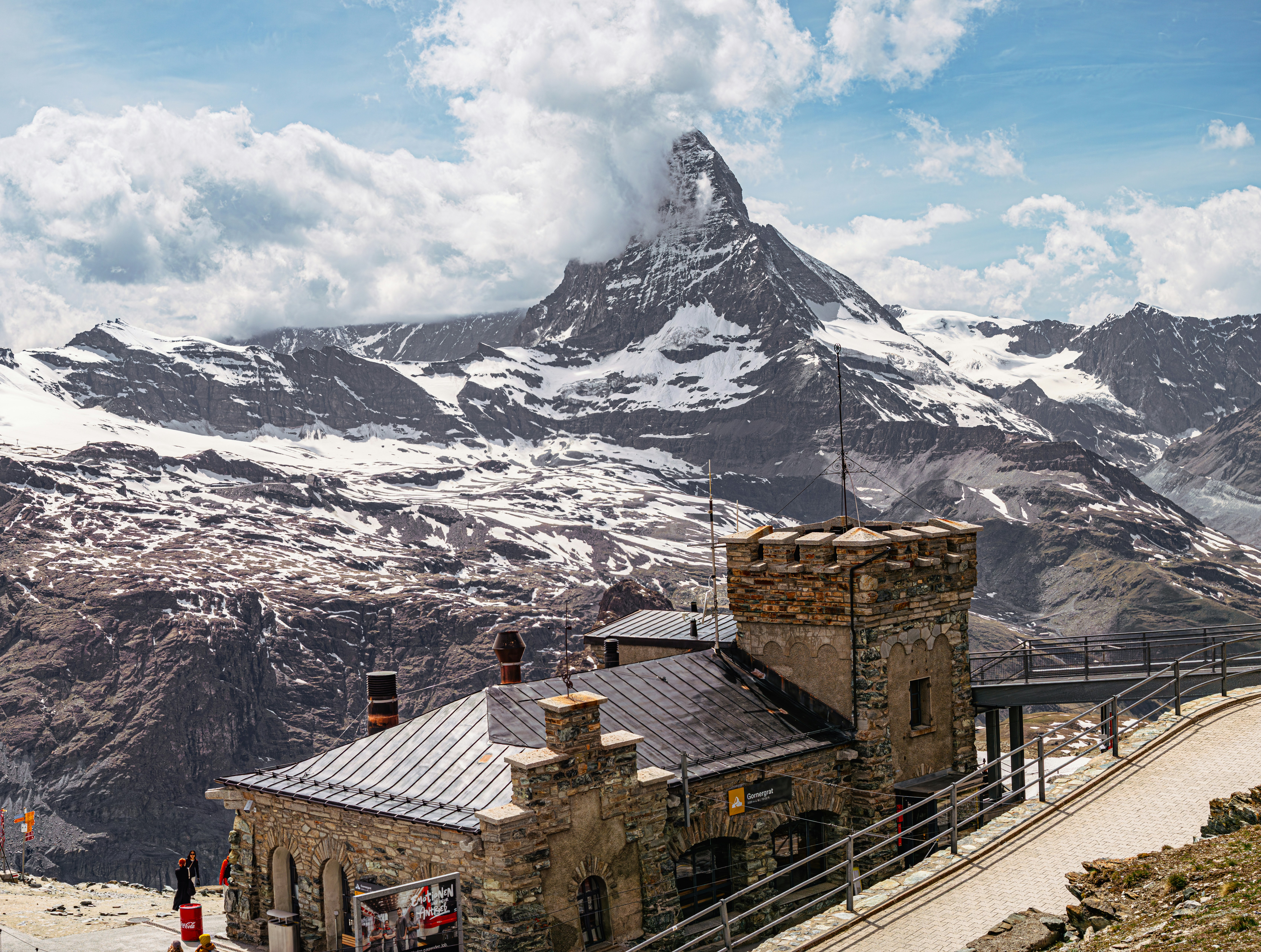 A historic stone mountain building above Zermatt with the snowy Matterhorn behind