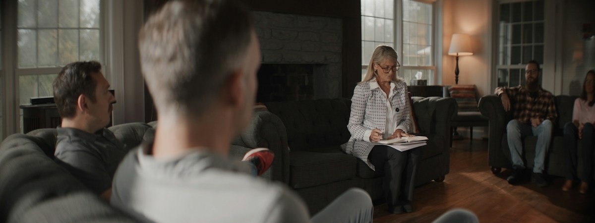 Adults discussing church event planning in a cozy living room setting.