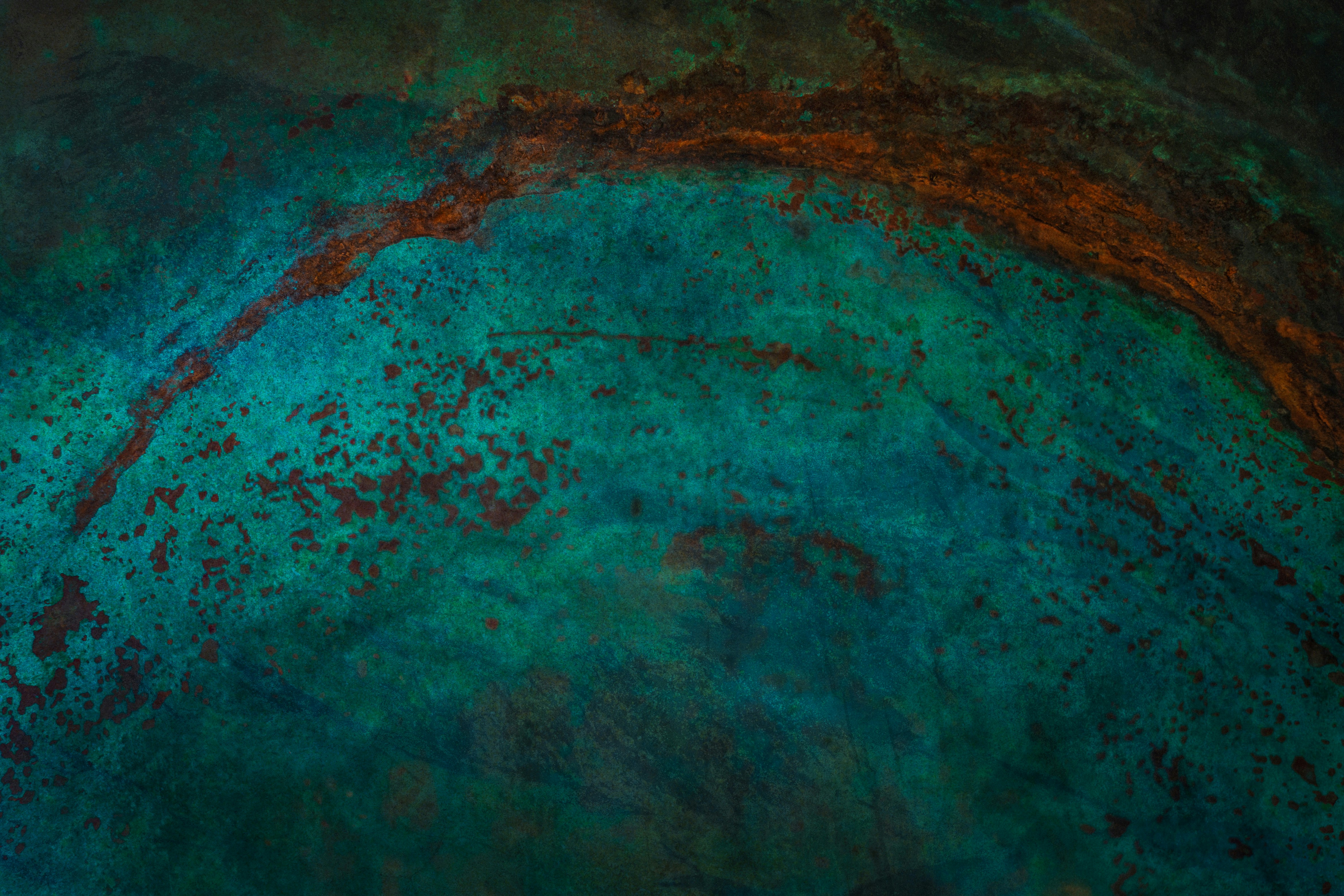 Abstract texture of teal and copper patina on metal.