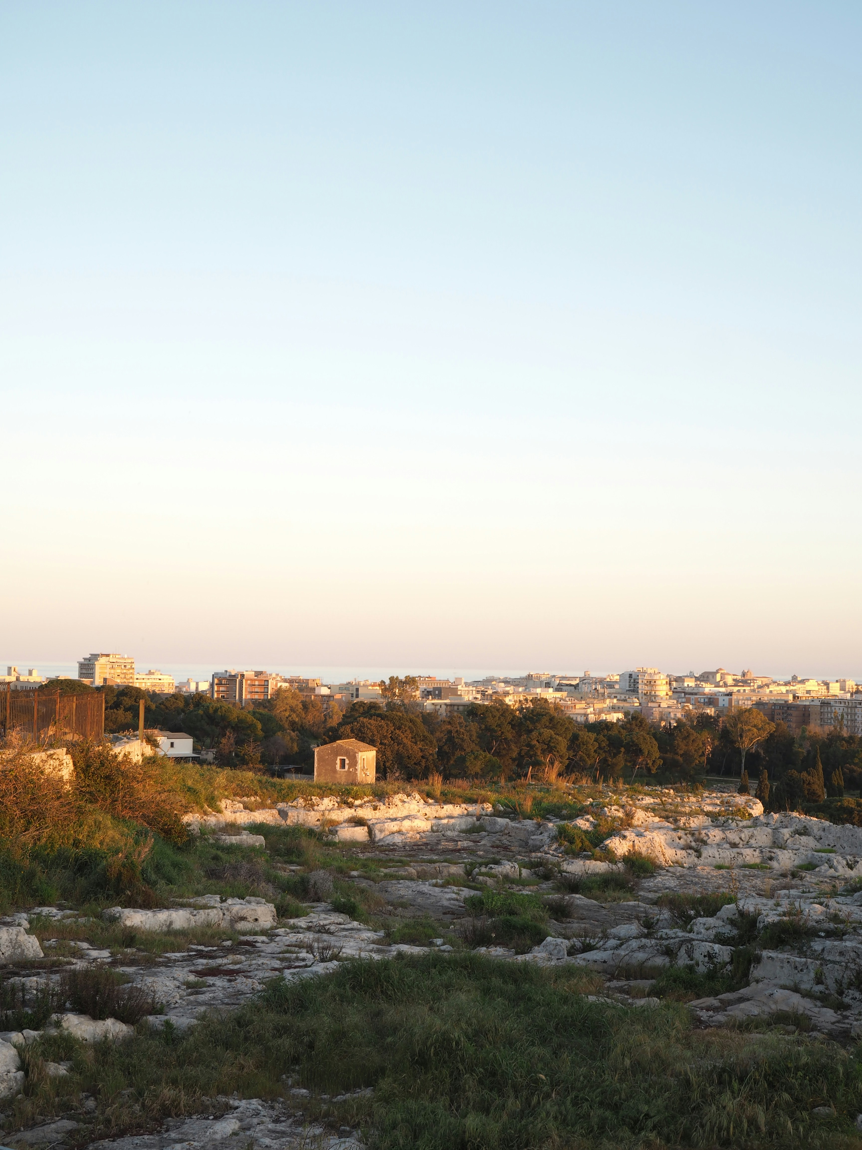 A city skyline in the distance with rocky terrain