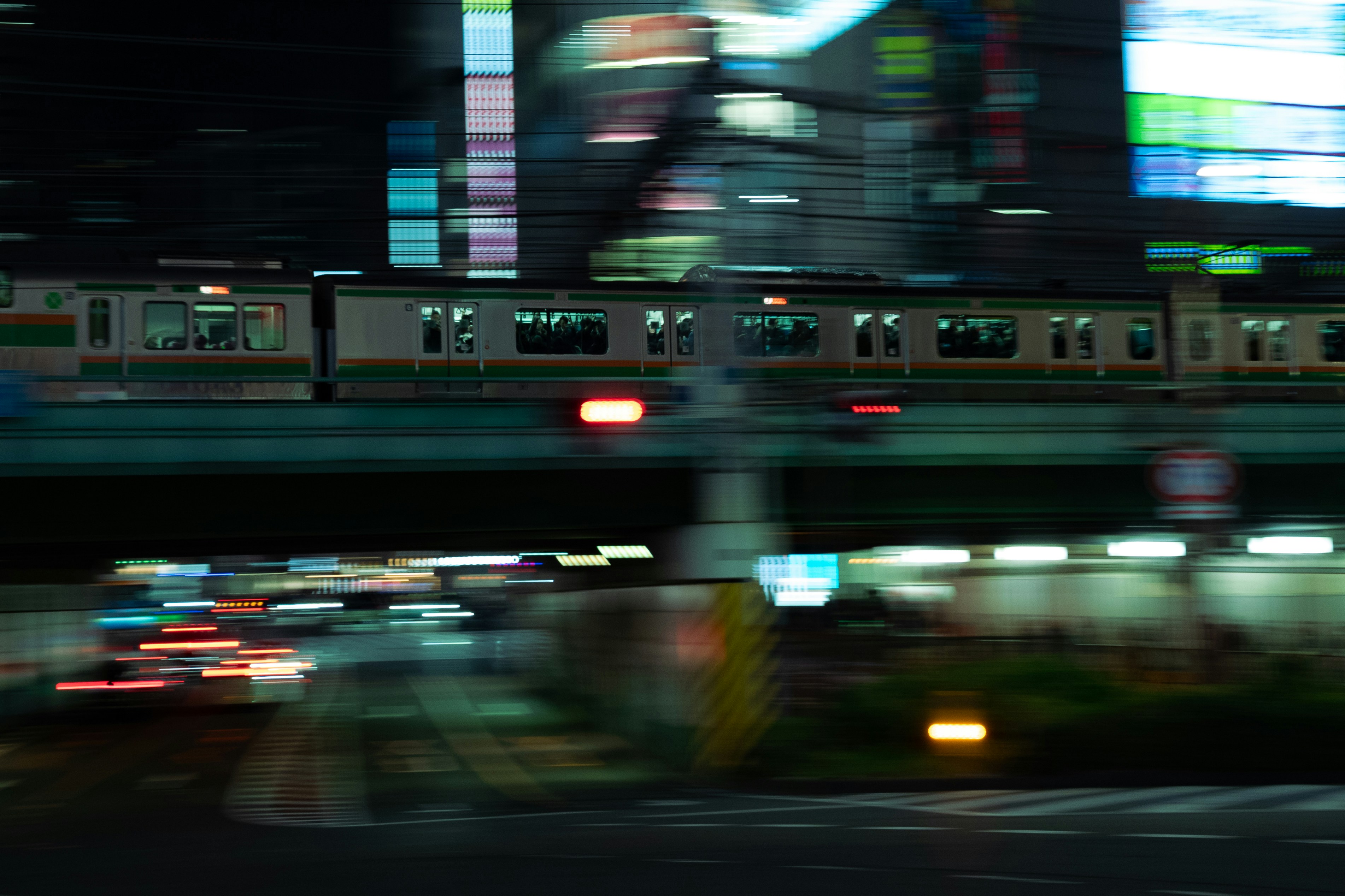 Nighttime cityscape with a fast-moving train and light trails.