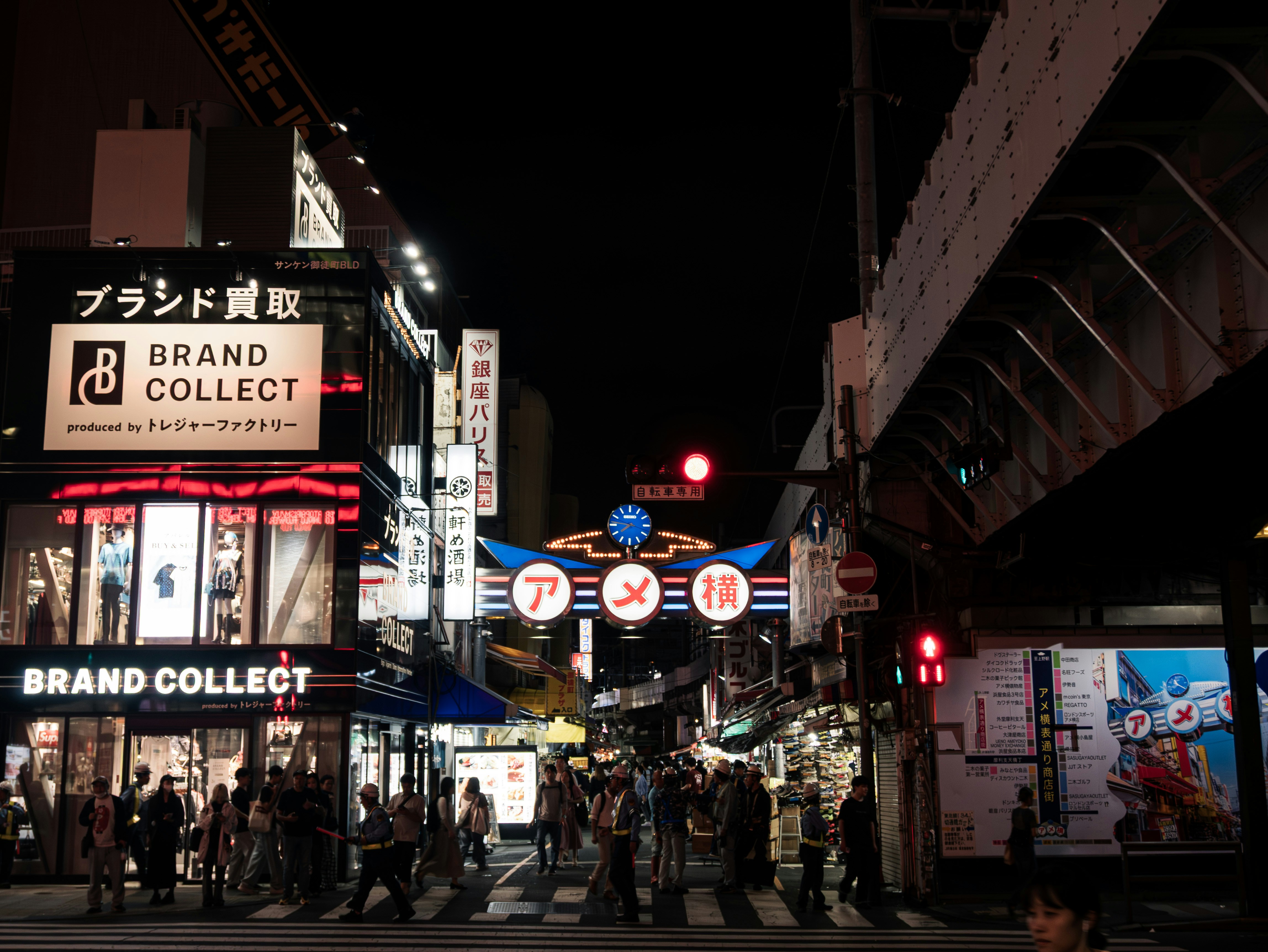 Illuminated street signs and people walking at night
