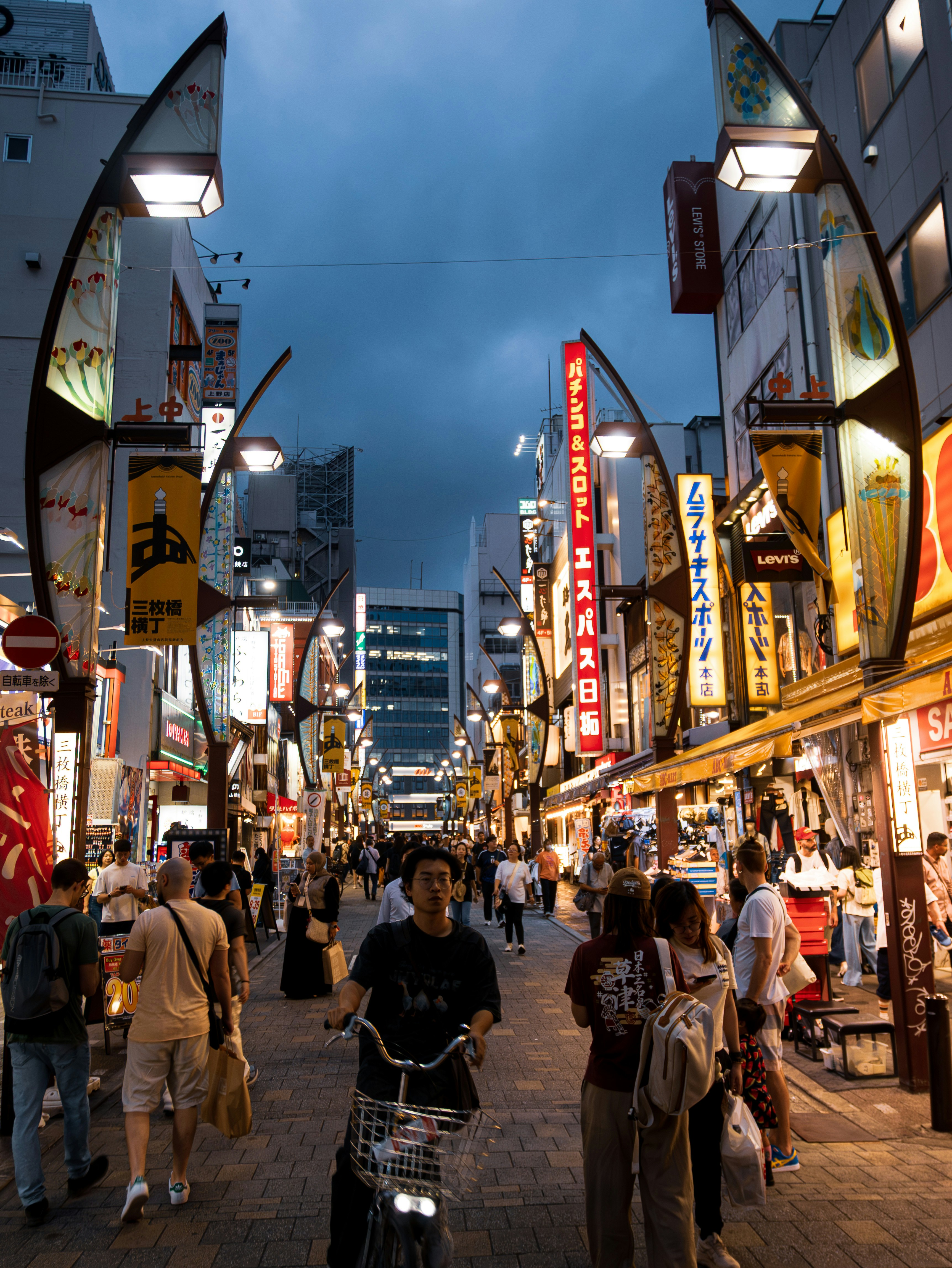 Crowded japanese street at night with illuminated shops and people