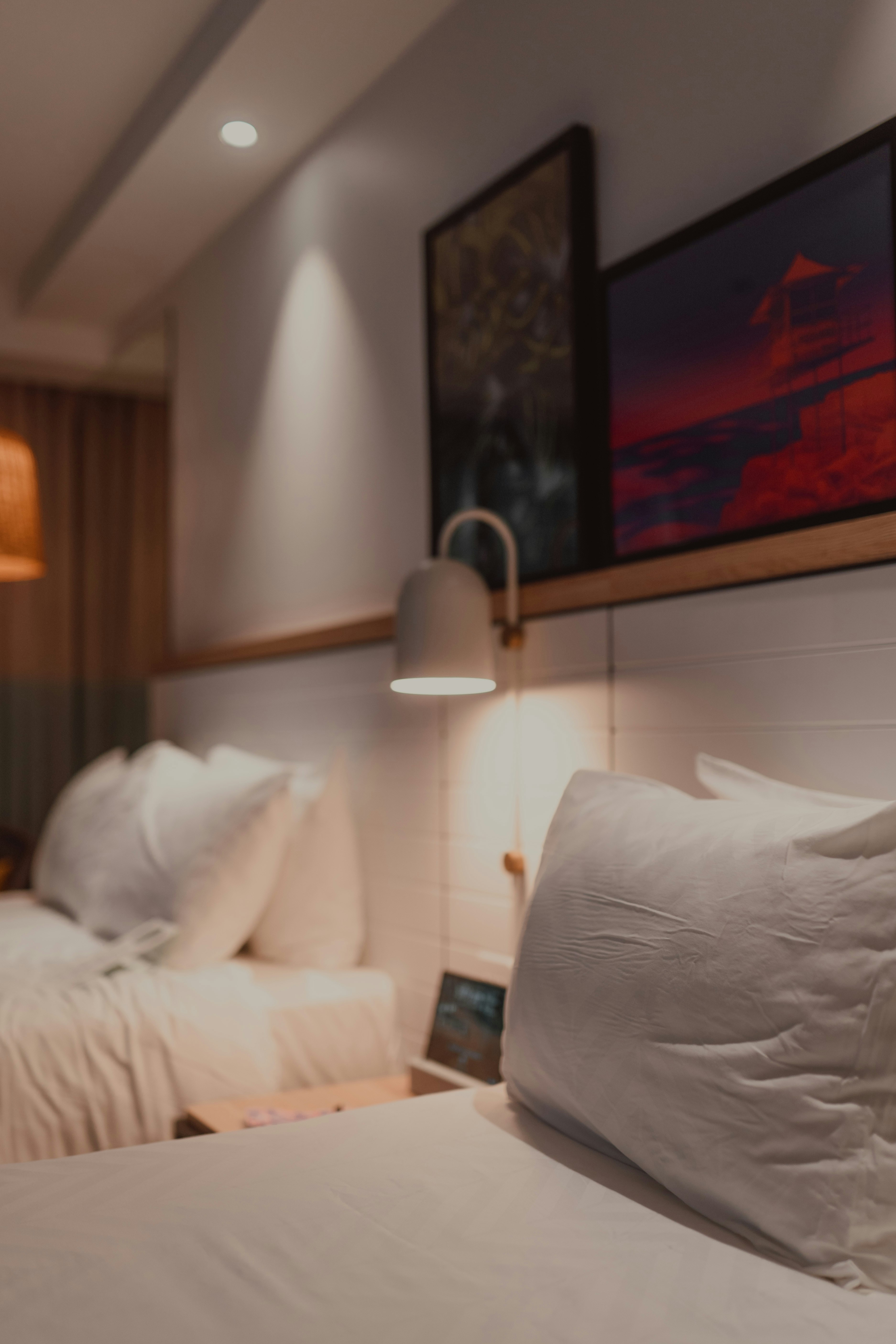 Cozy bedroom with two beds and warm lighting.