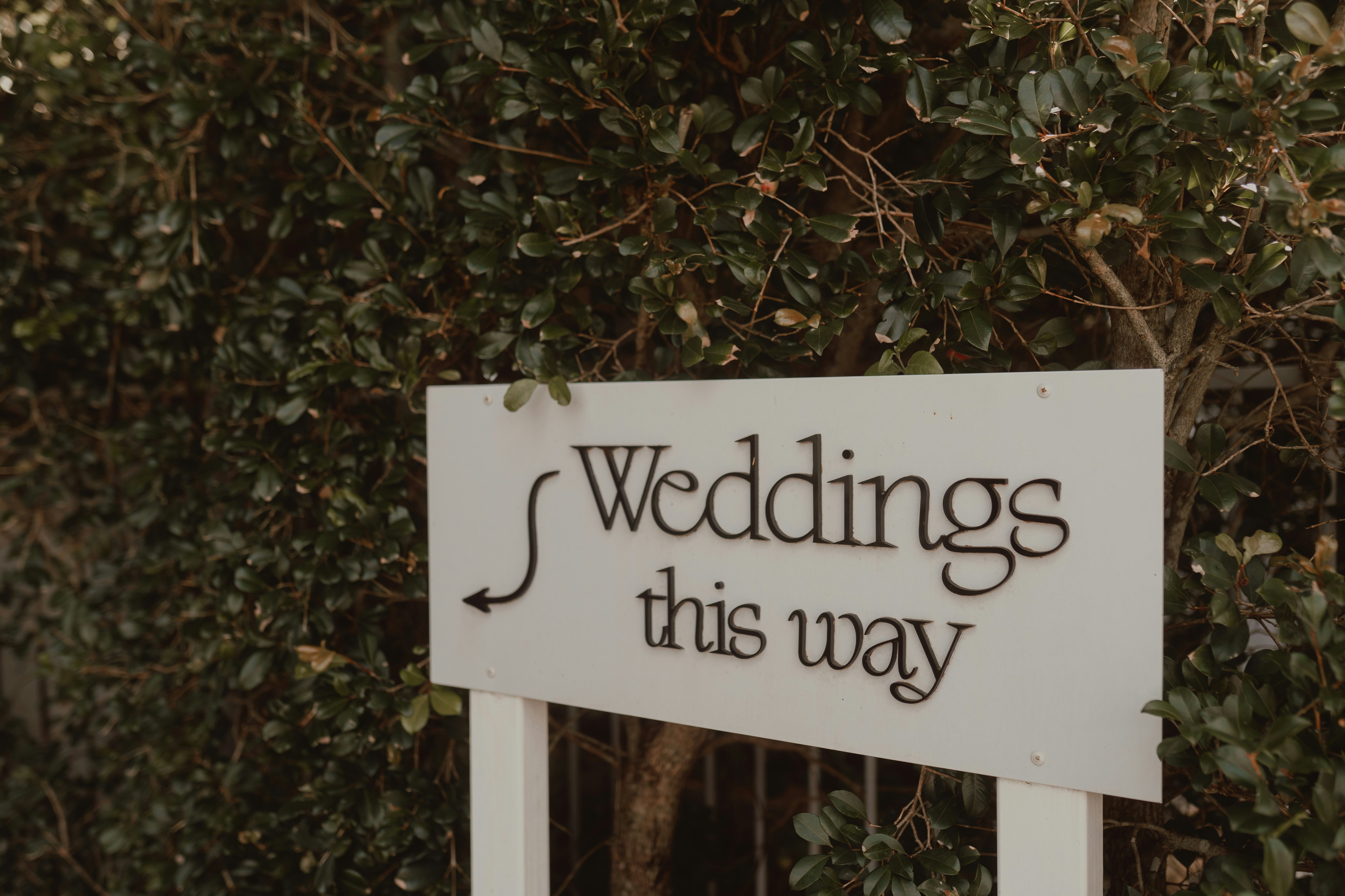 A wedding direction sign at a venue entrance helps guests find where to go on the day.
