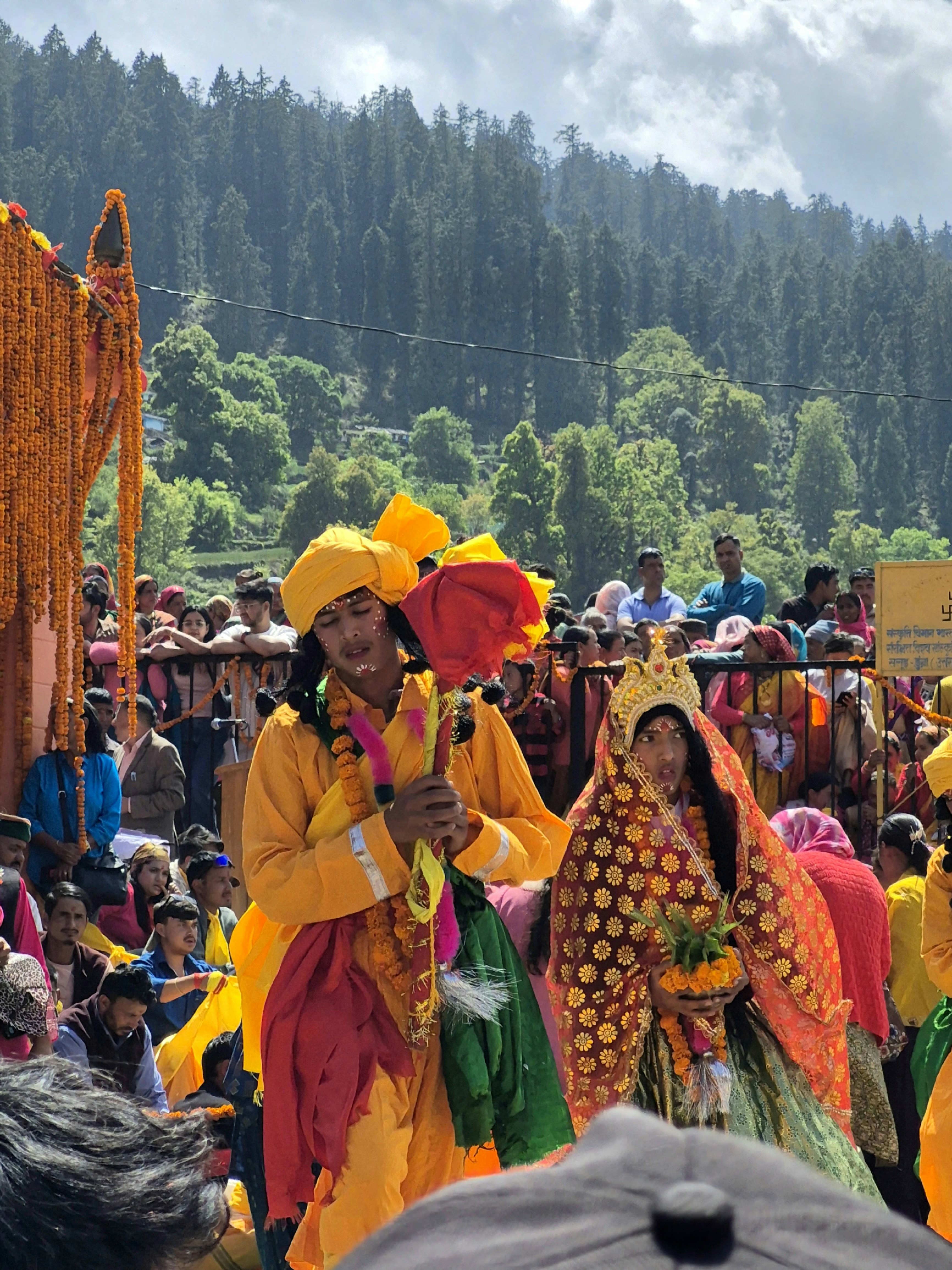 Orang-orang dengan pakaian tradisional yang semarak selama prosesi festival gunung.