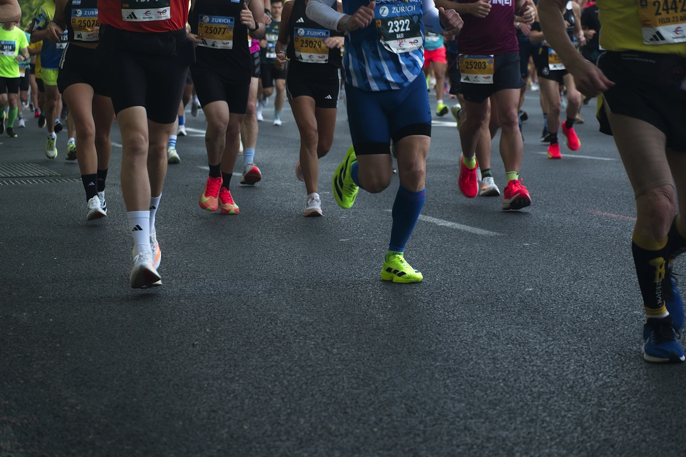Distance runners maintaining rhythm together on a road.