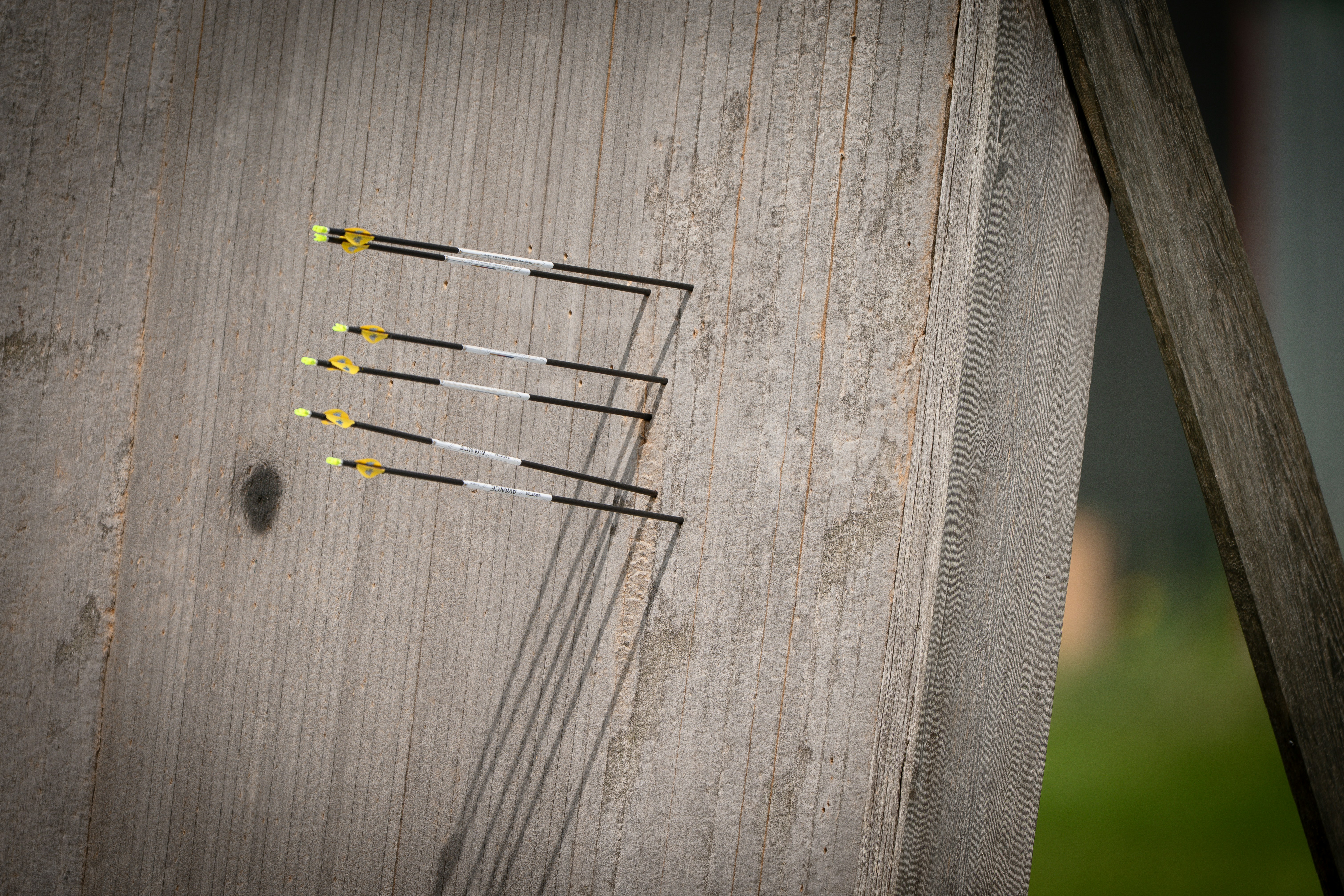 Several arrows are stuck in a wooden target board.