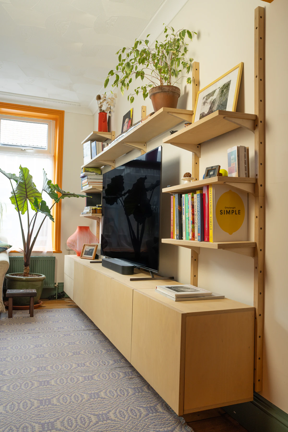 Wall-mounted television above a console with shelving either side