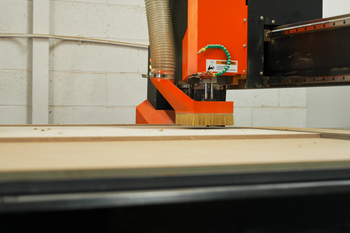 Automated machinery cutting building panels in a factory