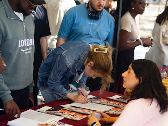 Woman signing paperwork at an outdoor event registration.