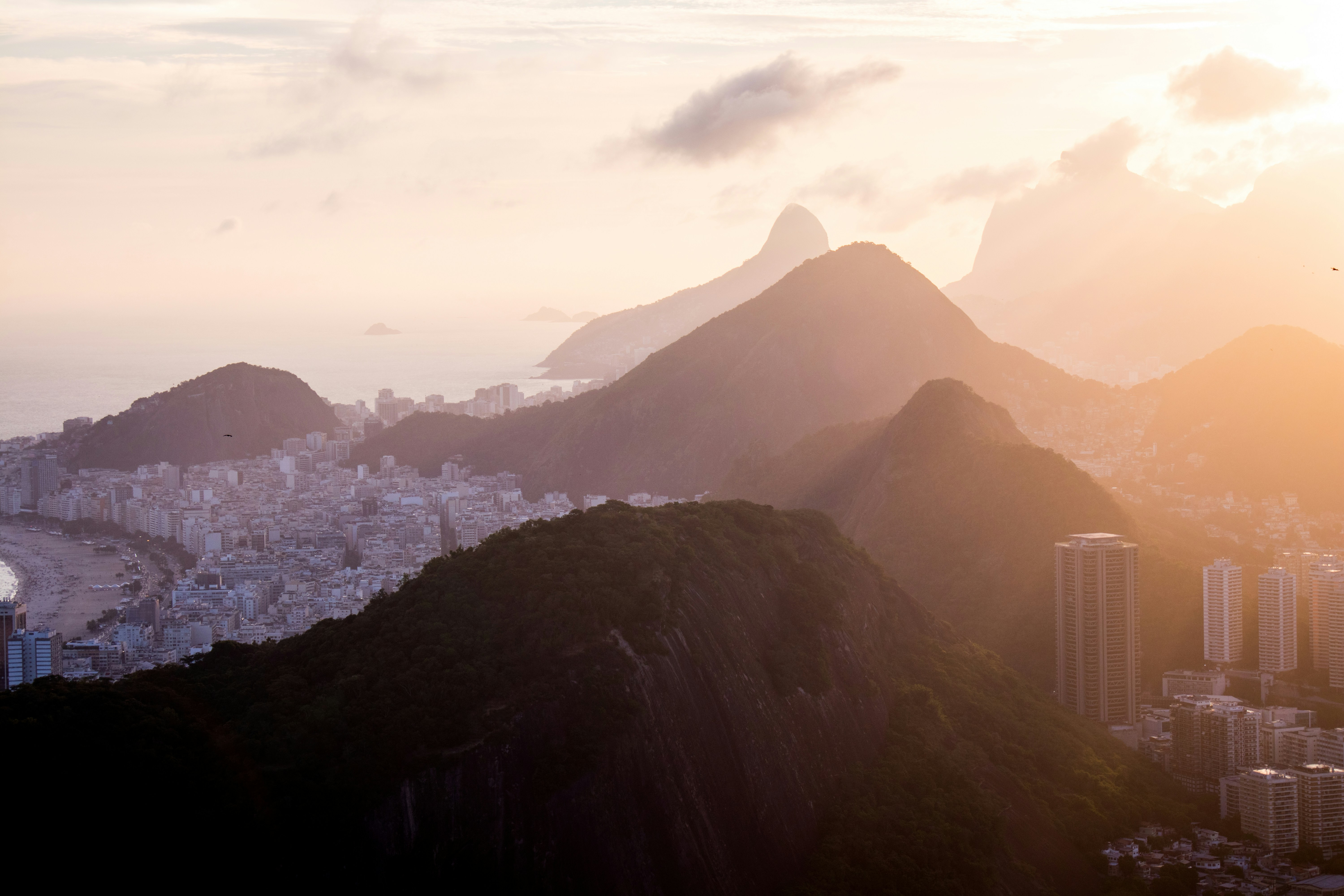 Hazy sunset over a mountainous cityscape with distant buildings. - 相关推荐