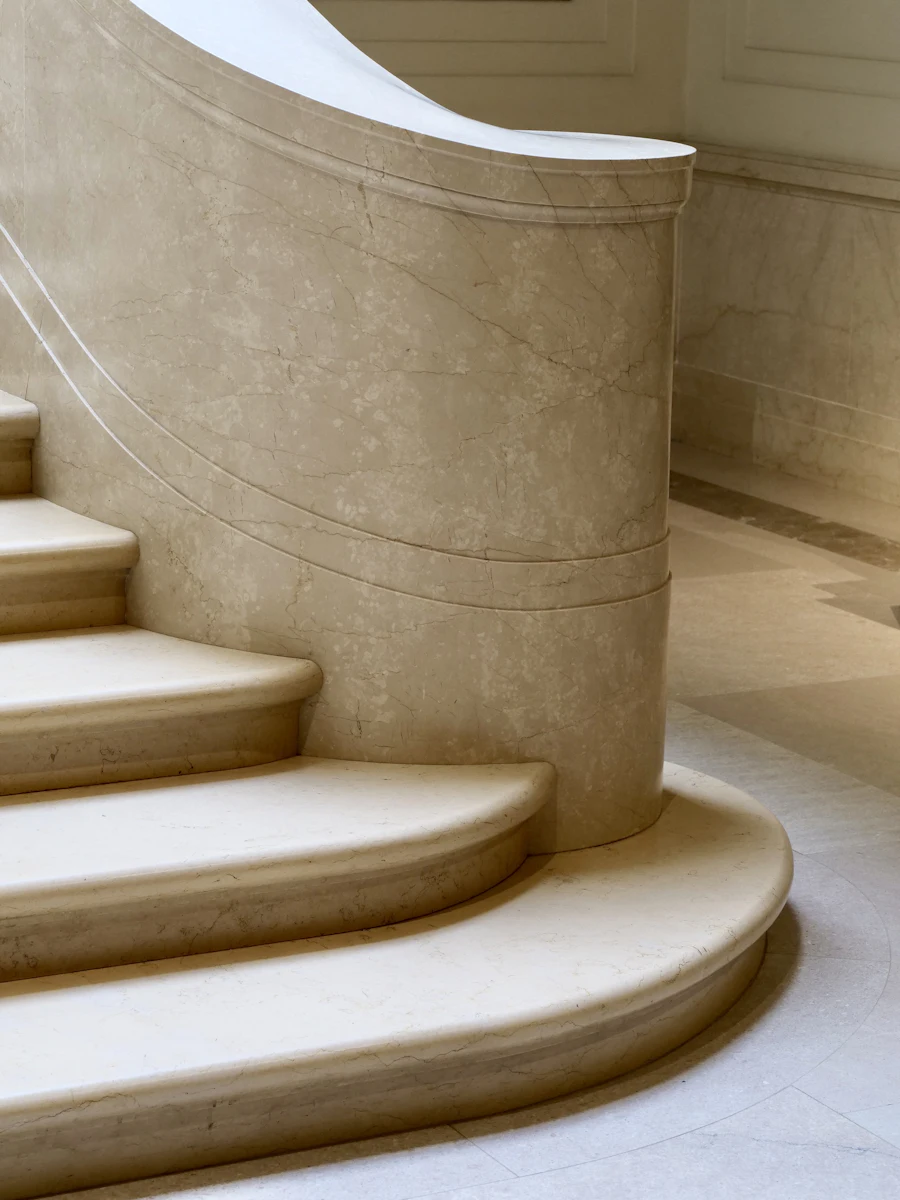 Curved pale stone staircase lit softly from one side