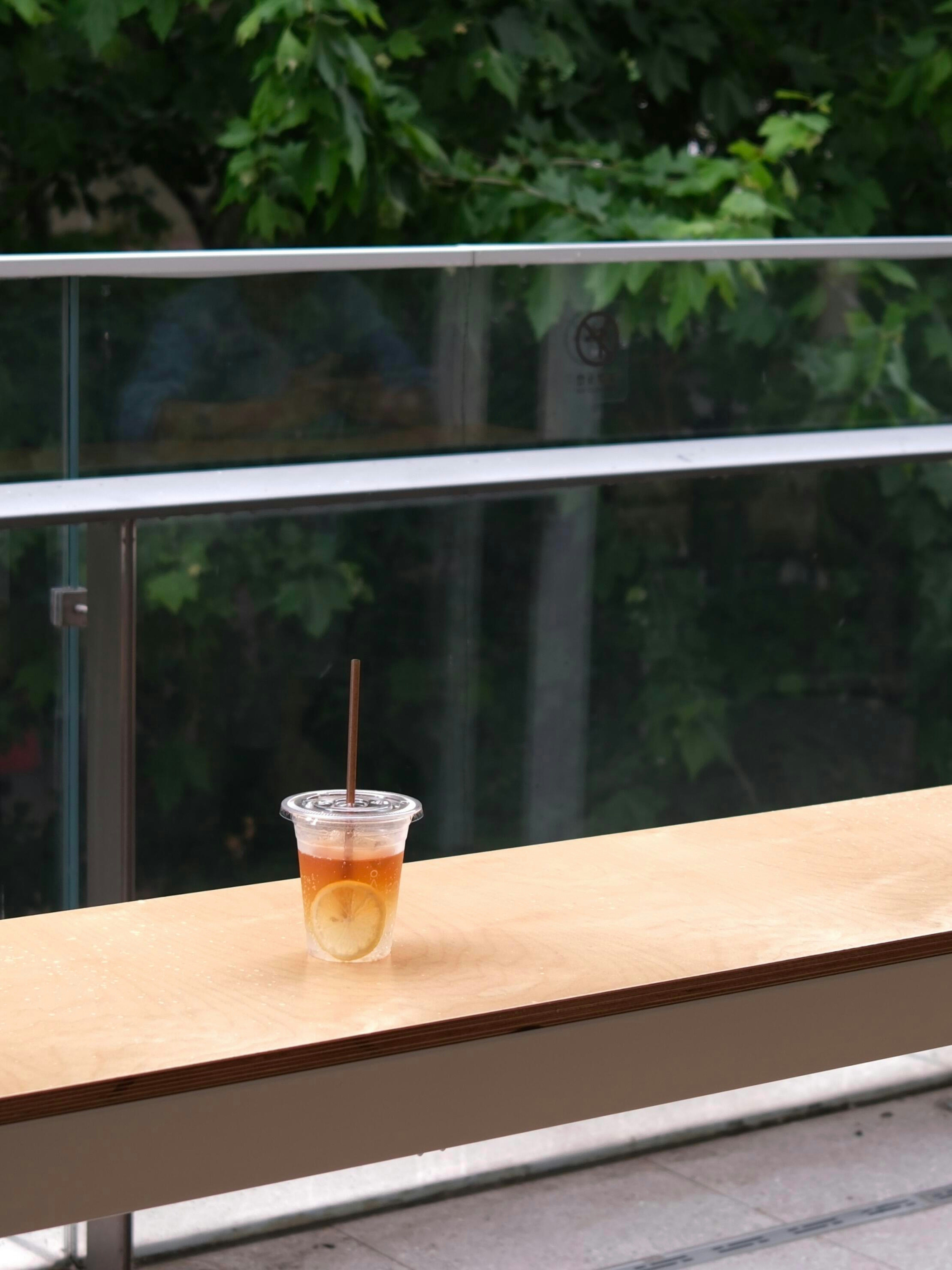 Thé glacé au citron sur un banc en bois à l’extérieur.