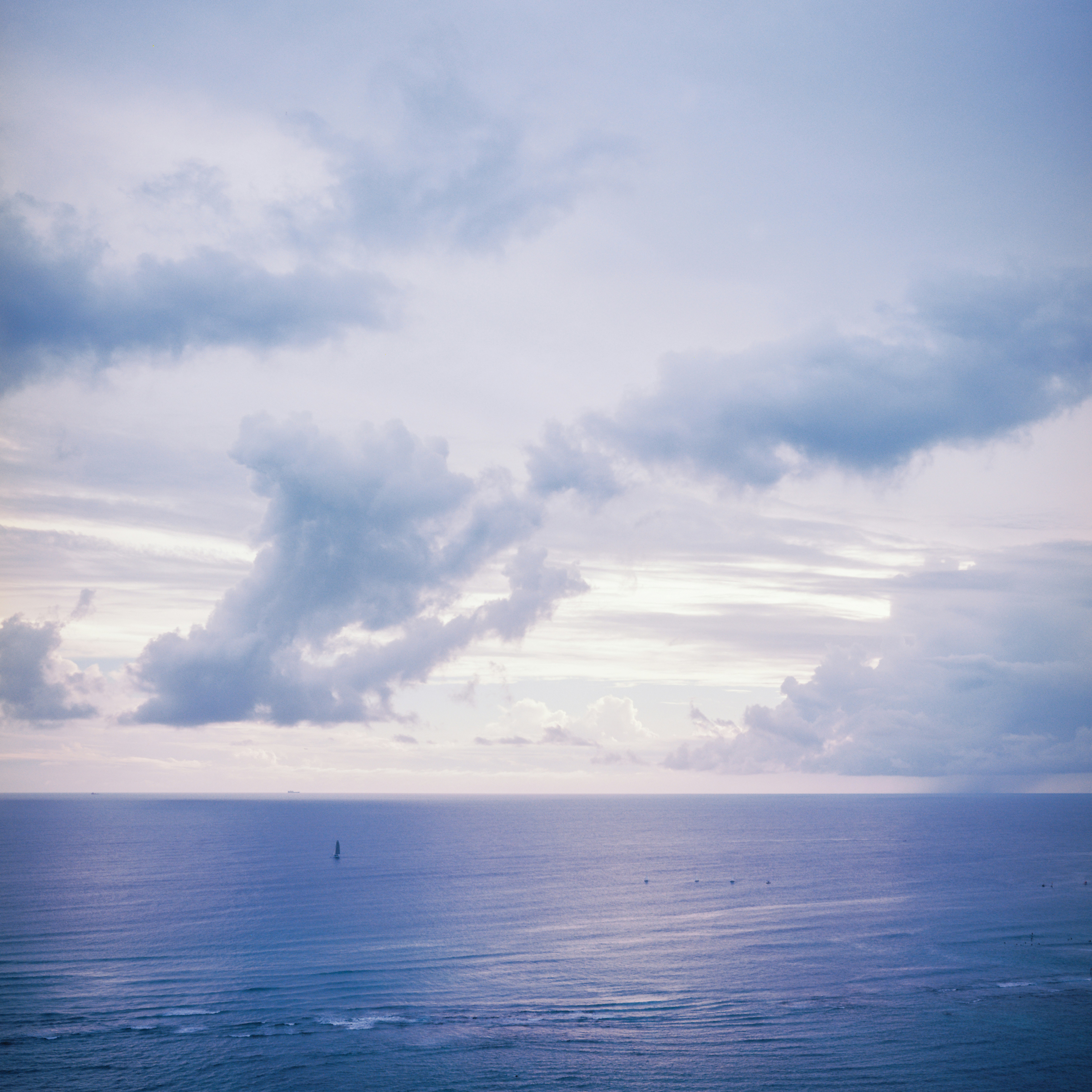 Vast ocean under a cloudy sky with a distant boat. - 相关推荐