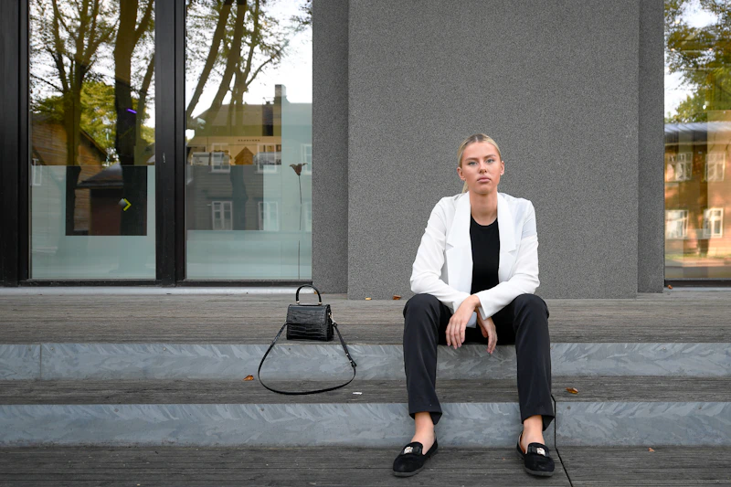 woman in a white blazer on building steps