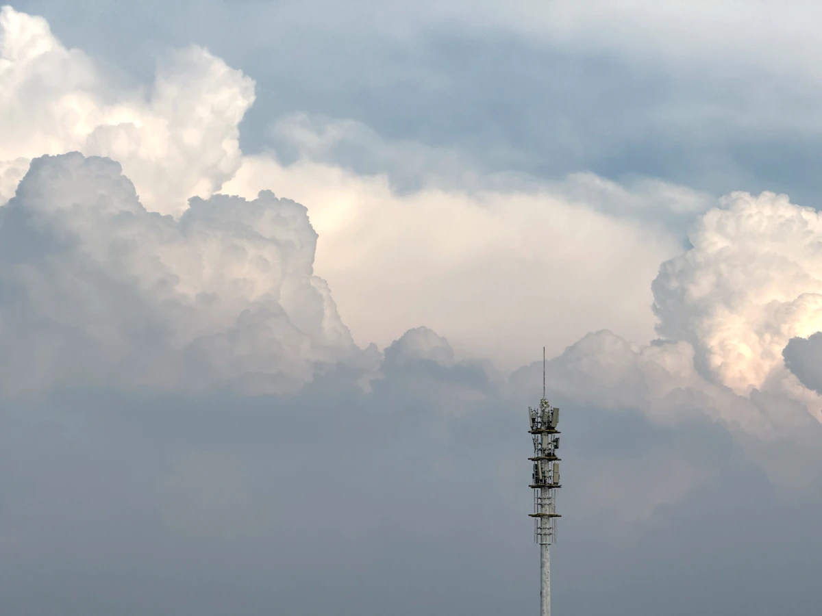 A telecommunications tower against a dramatic Caribbean sky, representing the regional infrastructure and connectivity policy at the centre of CARICOM's AI governance agenda