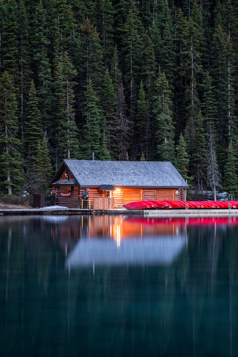 Canots rouges devant un chalet au bord d’un lac