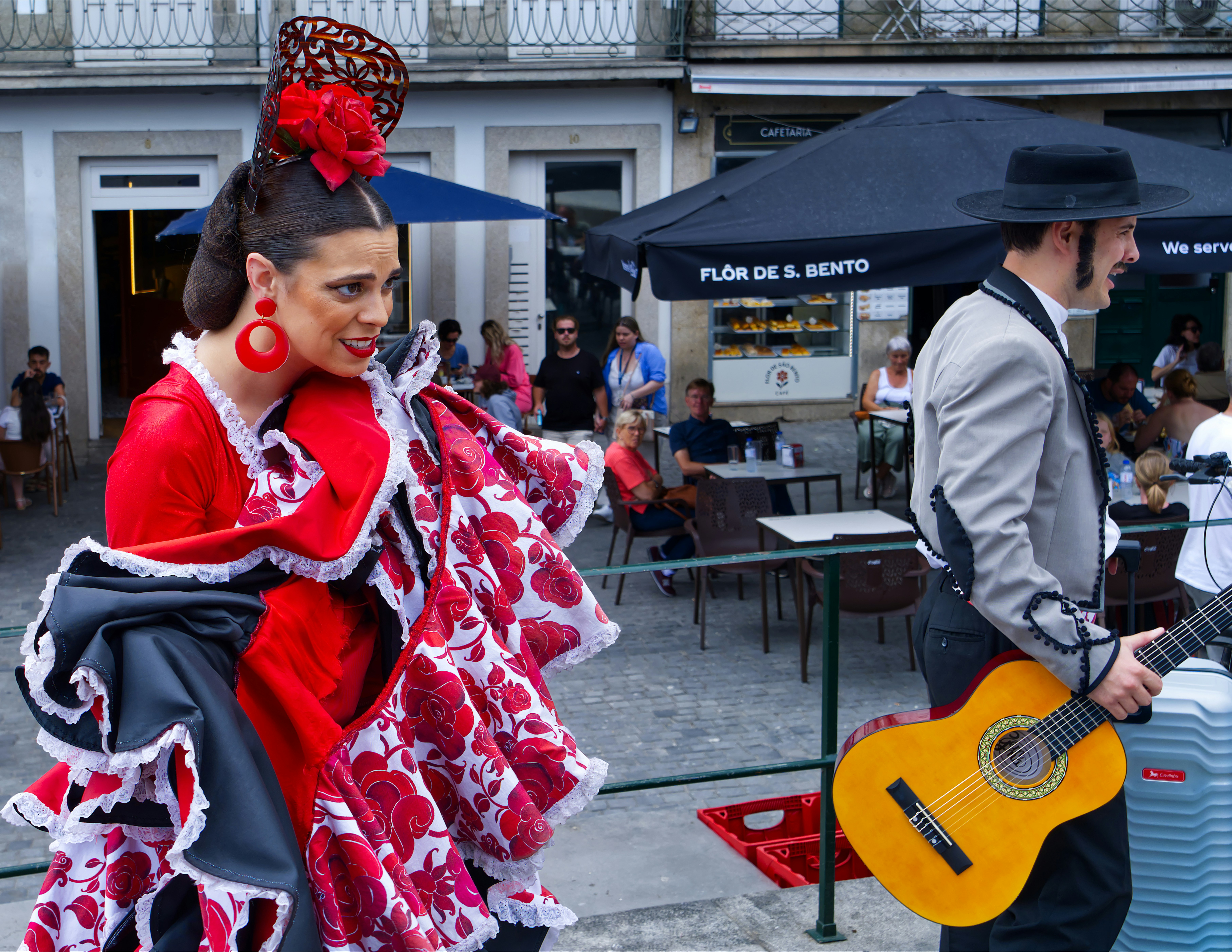 A flamenco dancer in a red ruffled dress performing beside a guitarist