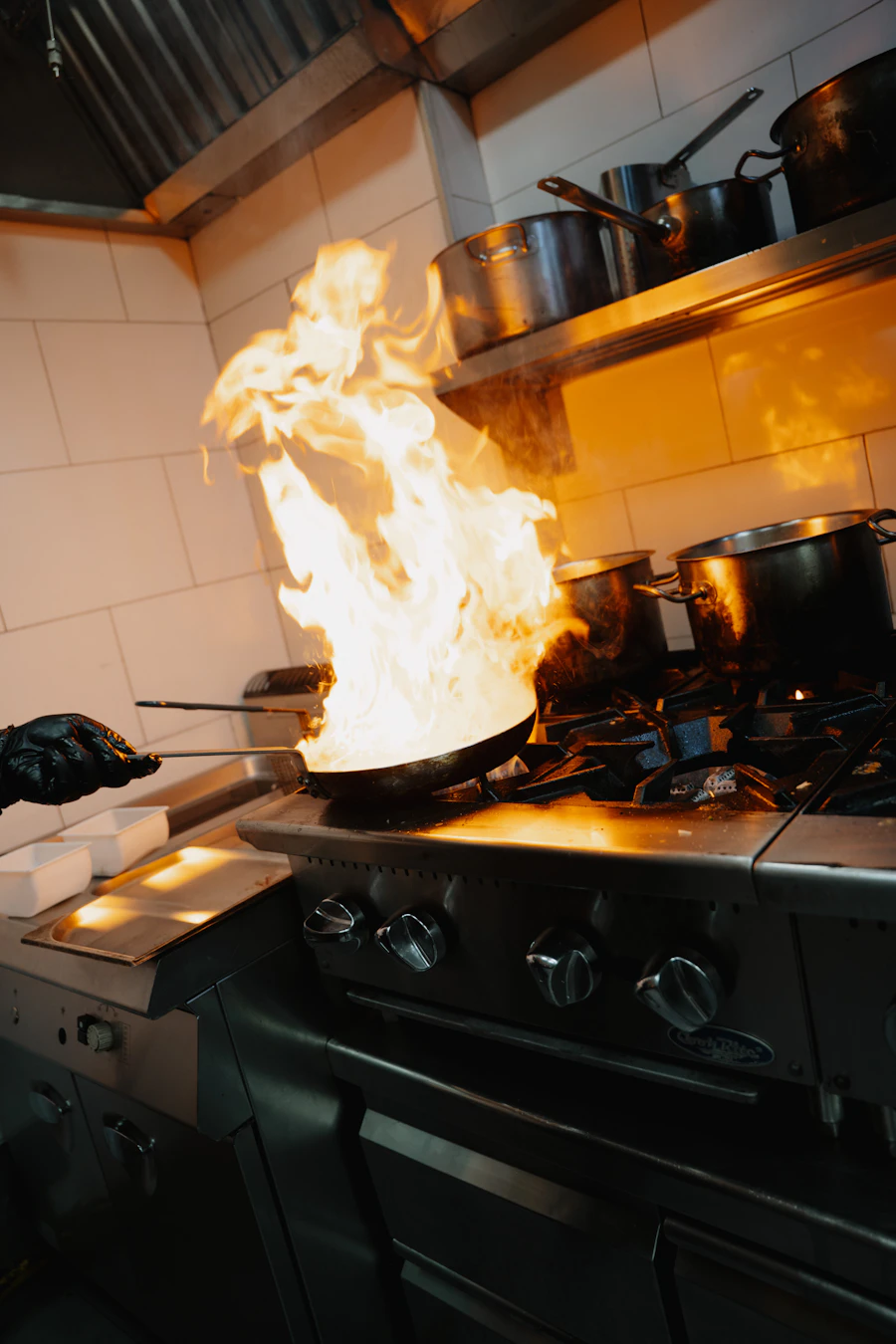 A commercial kitchen range roaring with flame