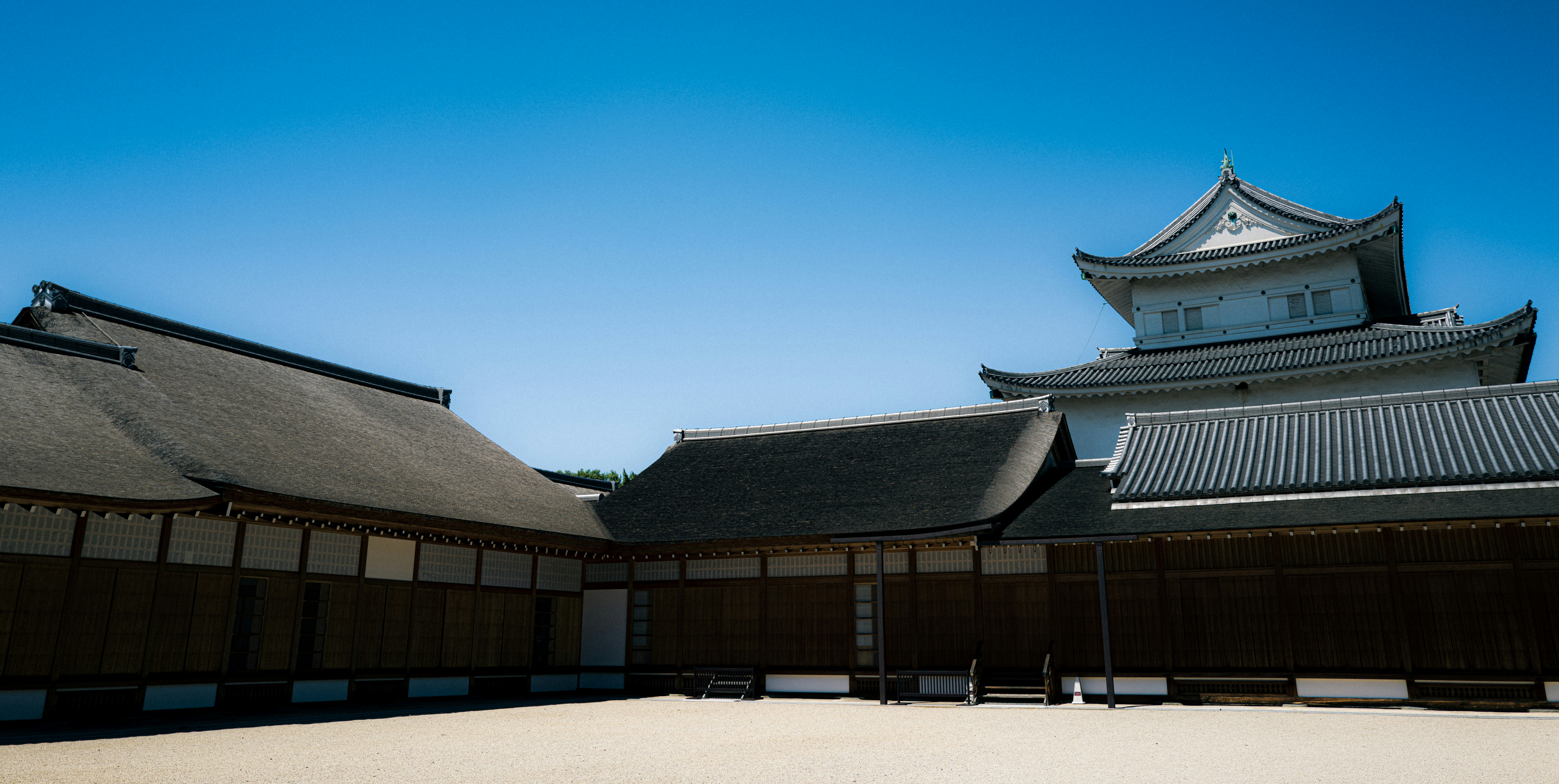 Traditional japanese castle buildings under a clear blue sky.